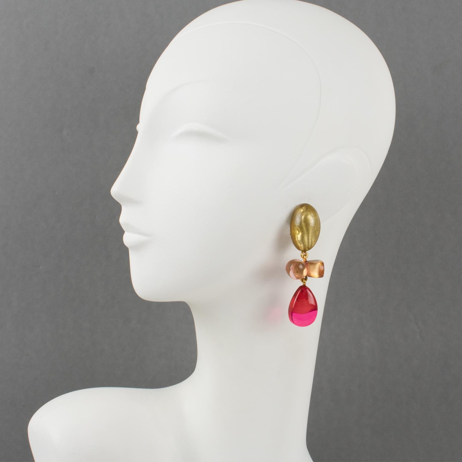 Dominique Denaive Paris designed these adorable clip-on earrings. They feature a dangling shape in resin with drops and free-forms in lovely powder pink, hot pink fuchsia, and transparent with pearlized gold inclusions. The engraved signature at the
