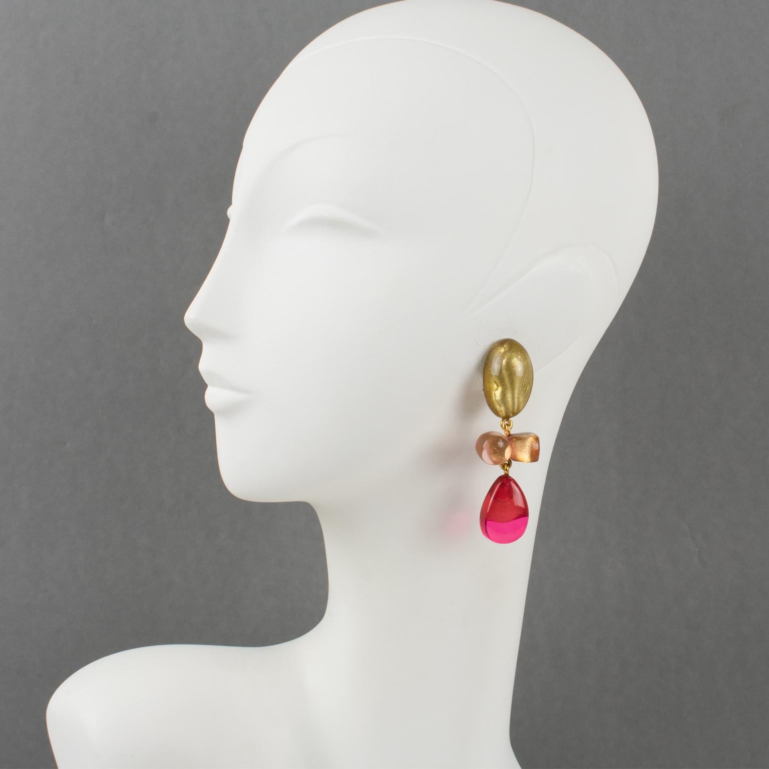 Dominique Denaive Paris designed these adorable clip-on earrings. They feature a dangling shape in resin with drops and free-forms in lovely powder pink, hot pink, fuchsia, and transparent with pearlized gold inclusions. The engraved signature at