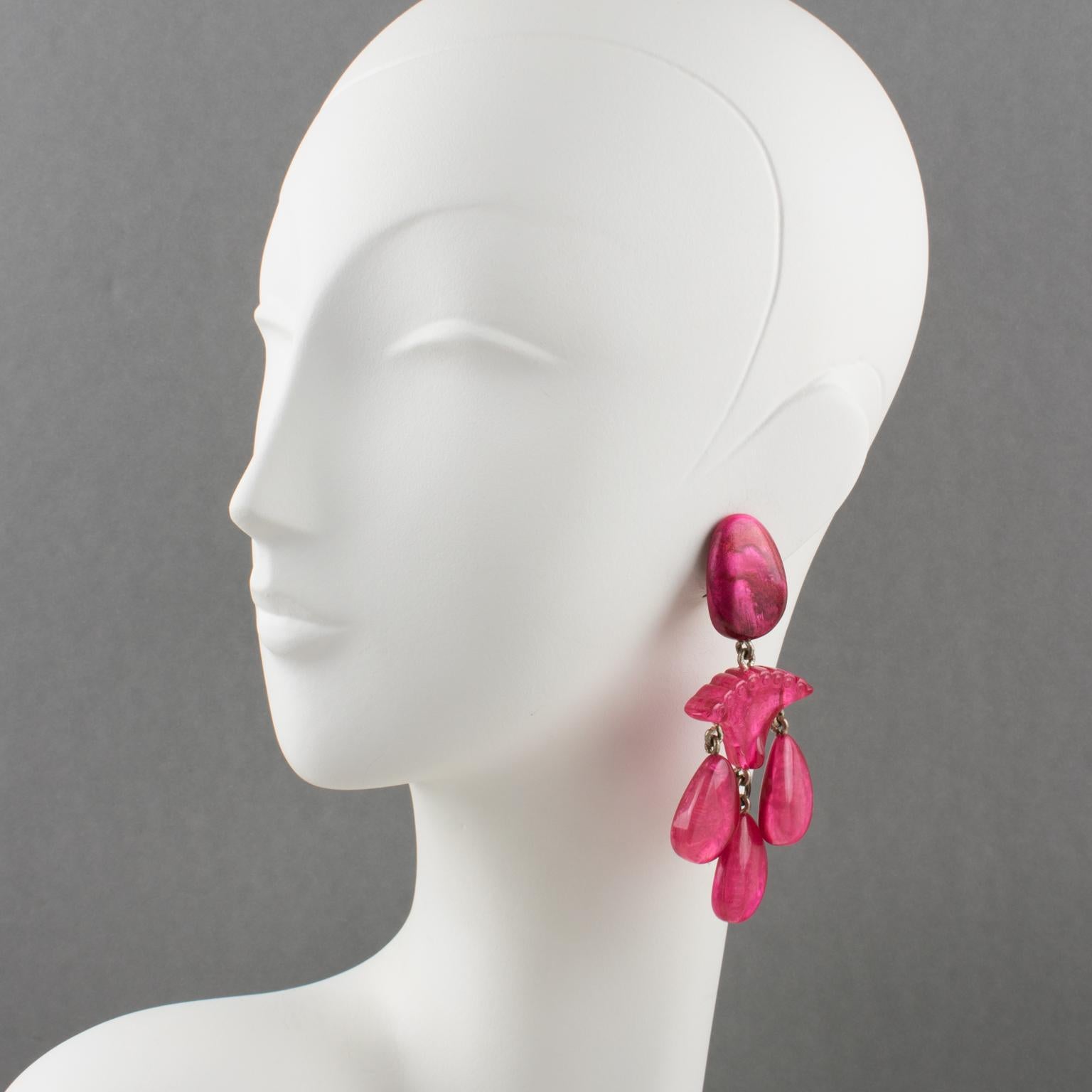 Stunning oversized clip-on earrings by Dominique Denaive Paris. Sculptural chandelier dangling shape, with carved resin, and drop charms in unusual moonglow hot pink color. Signed at the back of one earring with metal tag 