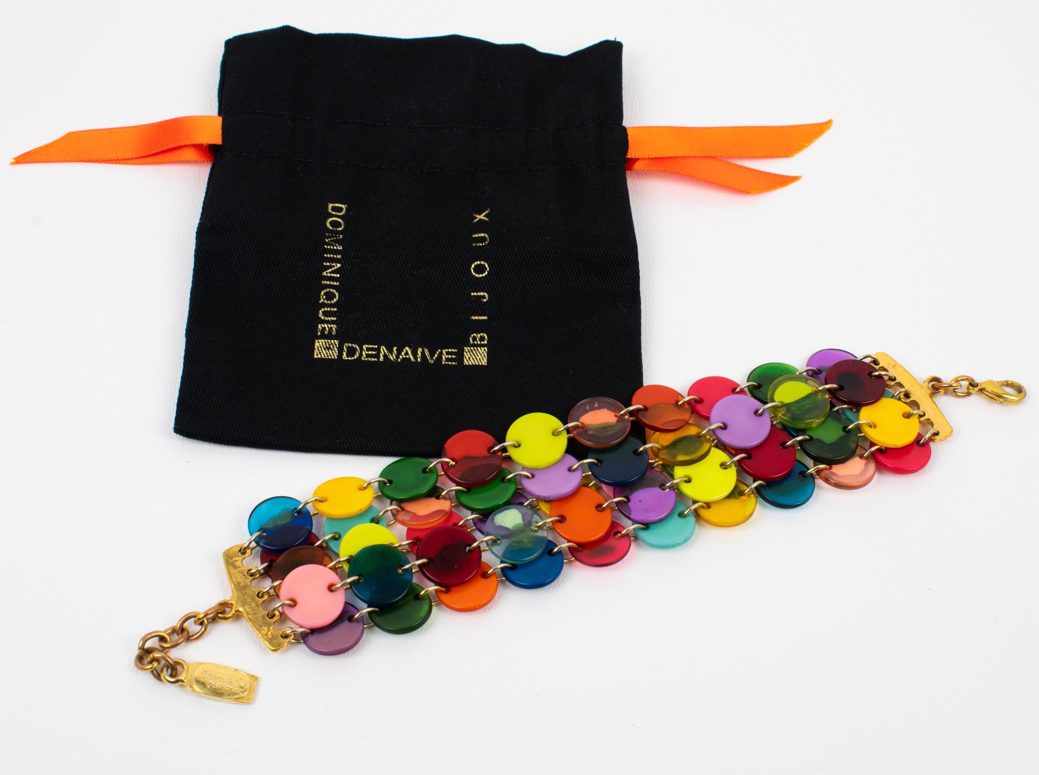 Ce superbe bracelet à maillons de Dominique Design/One Paris présente un design incroyable avec des éléments en résine et un encadrement en métal doré. La pièce comporte des pastilles multicolores tutti frutti dans des couleurs unies et marbrées. Le