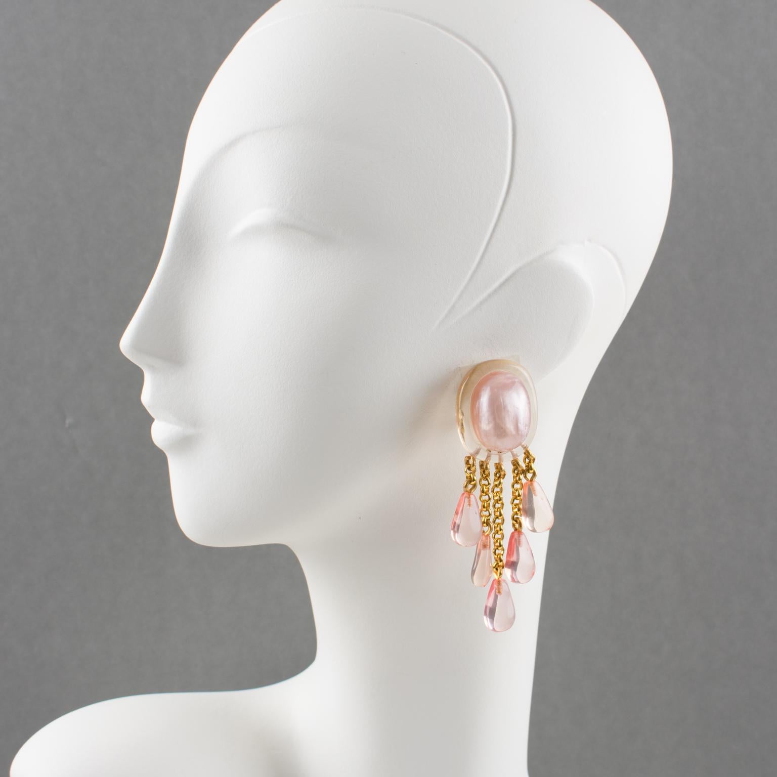 Stunning oversized clip-on earrings by Dominique Denaive Paris. Sculptural chandelier dangling shape, pearlized resin with carving and drop charms in unusual transparent pink salmon and mother-of-pearl pink colors. Gilt metal chains holding the drop