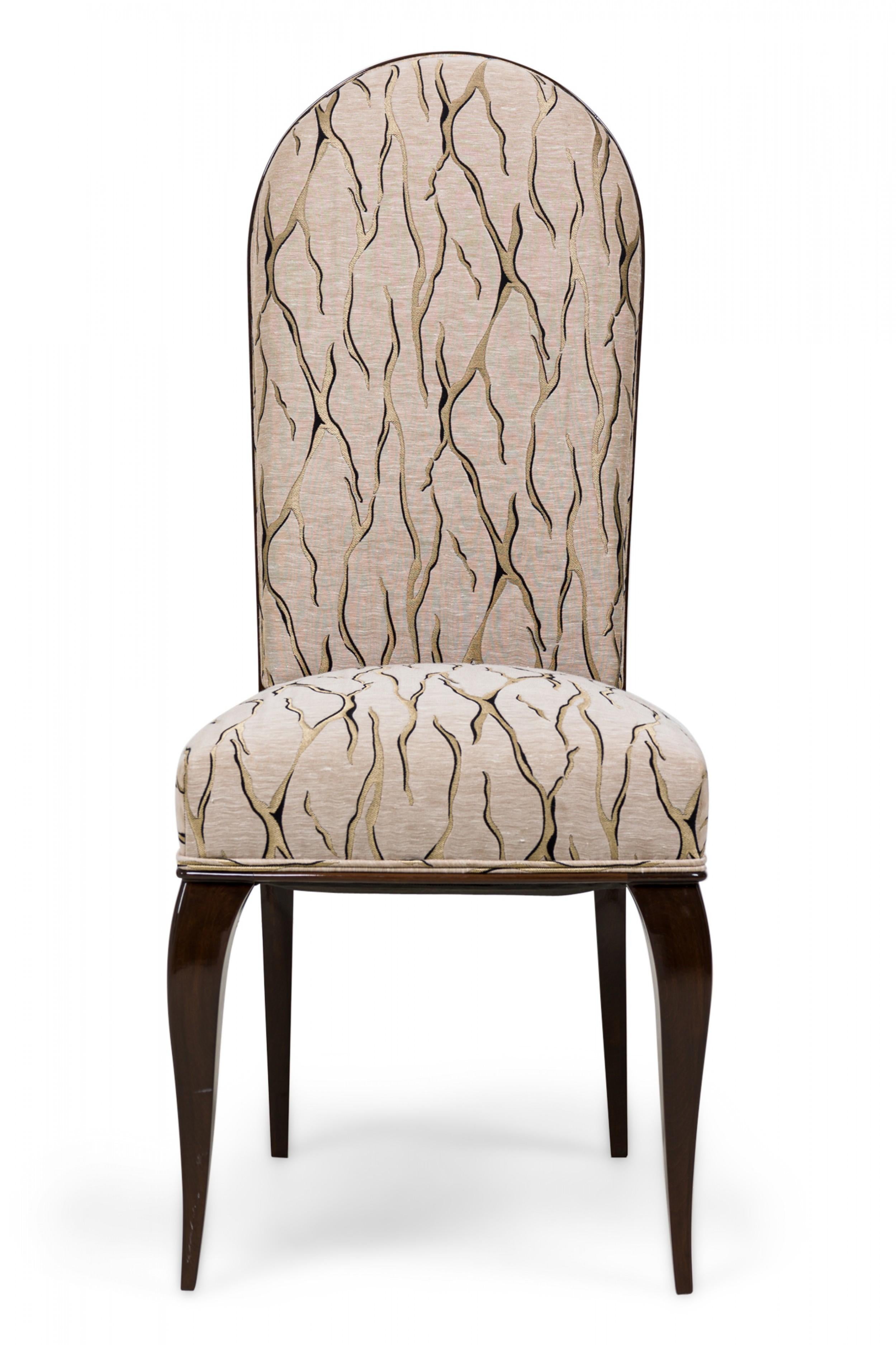 Set of 7 French Art Deco dining / side chairs with mahogany frames, upholstered in a beige patterned fabric with veins of gold, bordered with matching piping, resting on shaped mahogany legs. (Attributed to DOMINIQUE ET CIE)