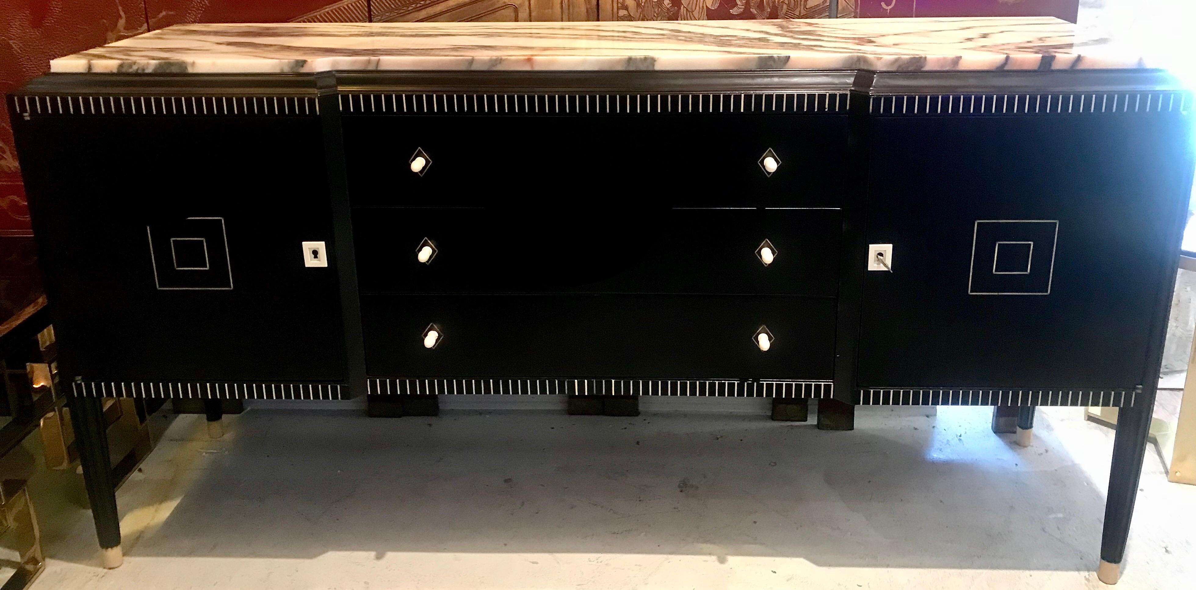 Sublime French art deco at it's best! A beautiful dark ebony of Macassar buffet with fluted wood trim and legs, bone accents and pulls topped with Carrara marble, for Maison Dominique.
