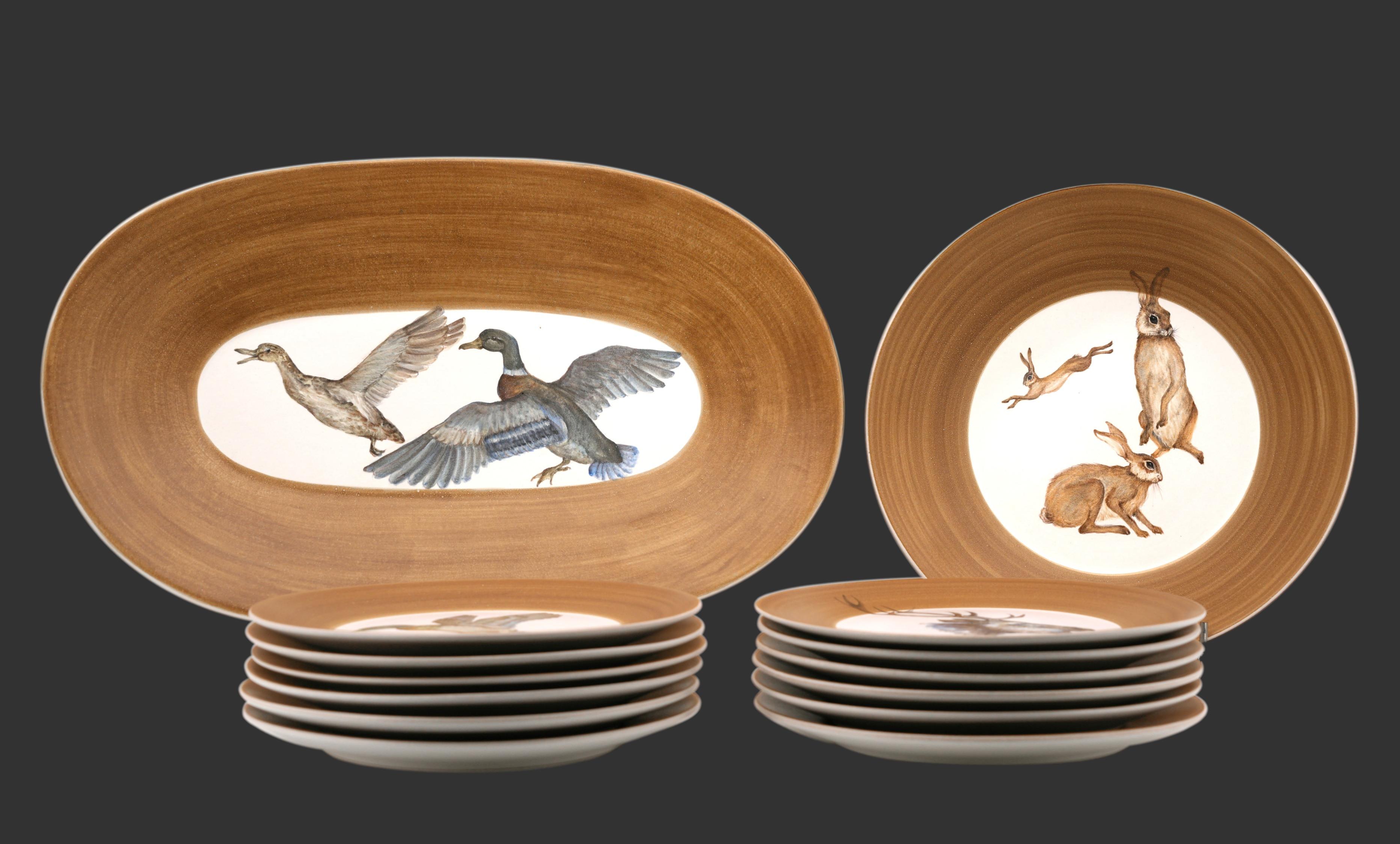 French Mid-century game hunting dinner set by Dominique GUILLOT, Vallauris, France, 1950s. Hand painted ceramic.
1 oval dish (19.7x12.4 in. - 50x31.5 cm)
1 round dish (diameter 12.1 in. -30.8cm / height 3.15 in. - 8cm)
12 plates (diameter 9.45 in. -