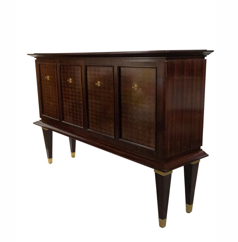 French Art Deco Macassar sideboard having 4 doors and keys with inlaid marquetry design and decorative bronze escutcheons and feet on tapered square legs (signed: DOMINIQUE on back).