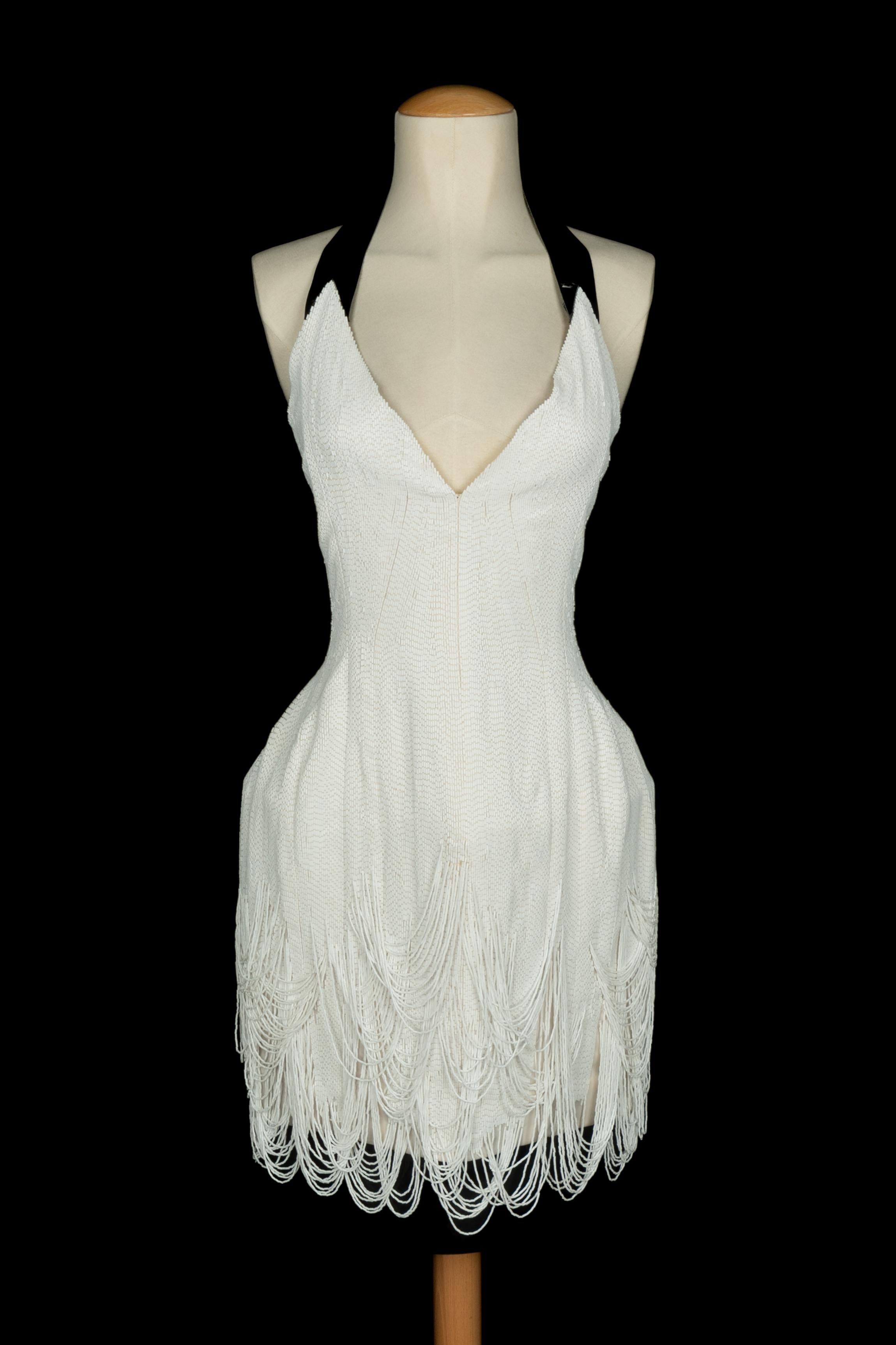 DOMINIQUE SIROP - Mittellanges Kleid, vollständig mit weißen Schlauchperlen bestickt, mit schwarzem Lacklederkragen und -unterteil. Keine Größenangabe, es passt eine 36FR. A 2011 Collection'S.

Bedingung:
Sehr guter