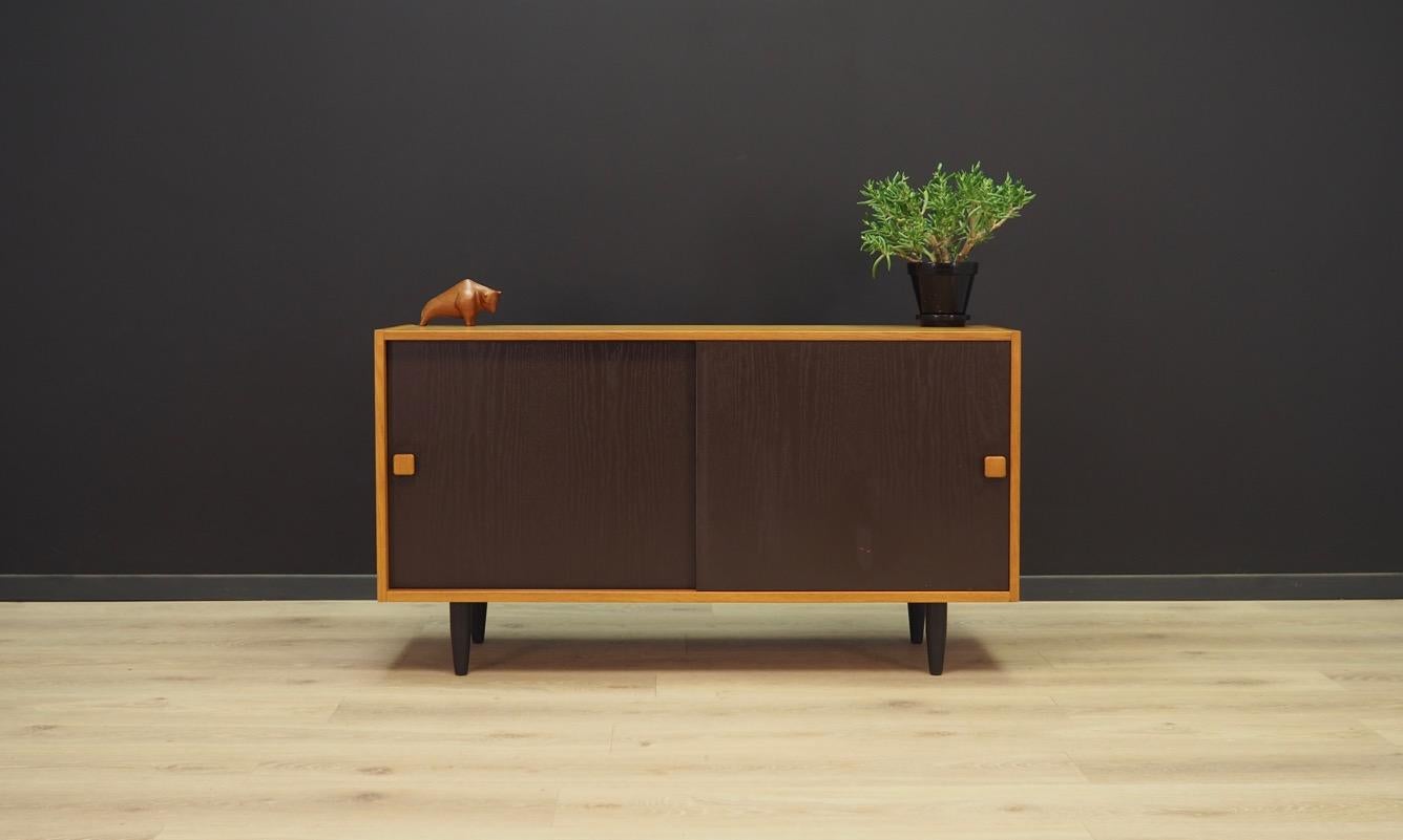 Classic cabinet from the 1960s-1970s, Danish design. Manufactured by Domino Møbler. The furniture is finished with ash veneer, the doors in black. Two shelves inside. Maintained in good condition (minor bruises and scratches, filled veneer