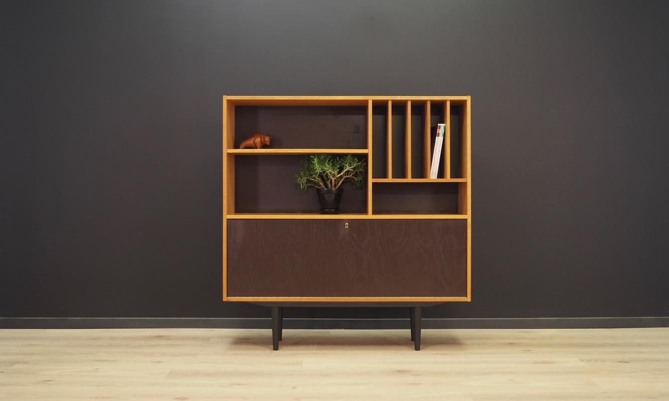 A fantastic bookcase, library from the 1960s-1970s, minimalistic form. Manufactured by Domino Møbler. Furniture finished with ash veneer, bar in black. Key included. Maintained in good condition (minor bruises and scratches), directly to