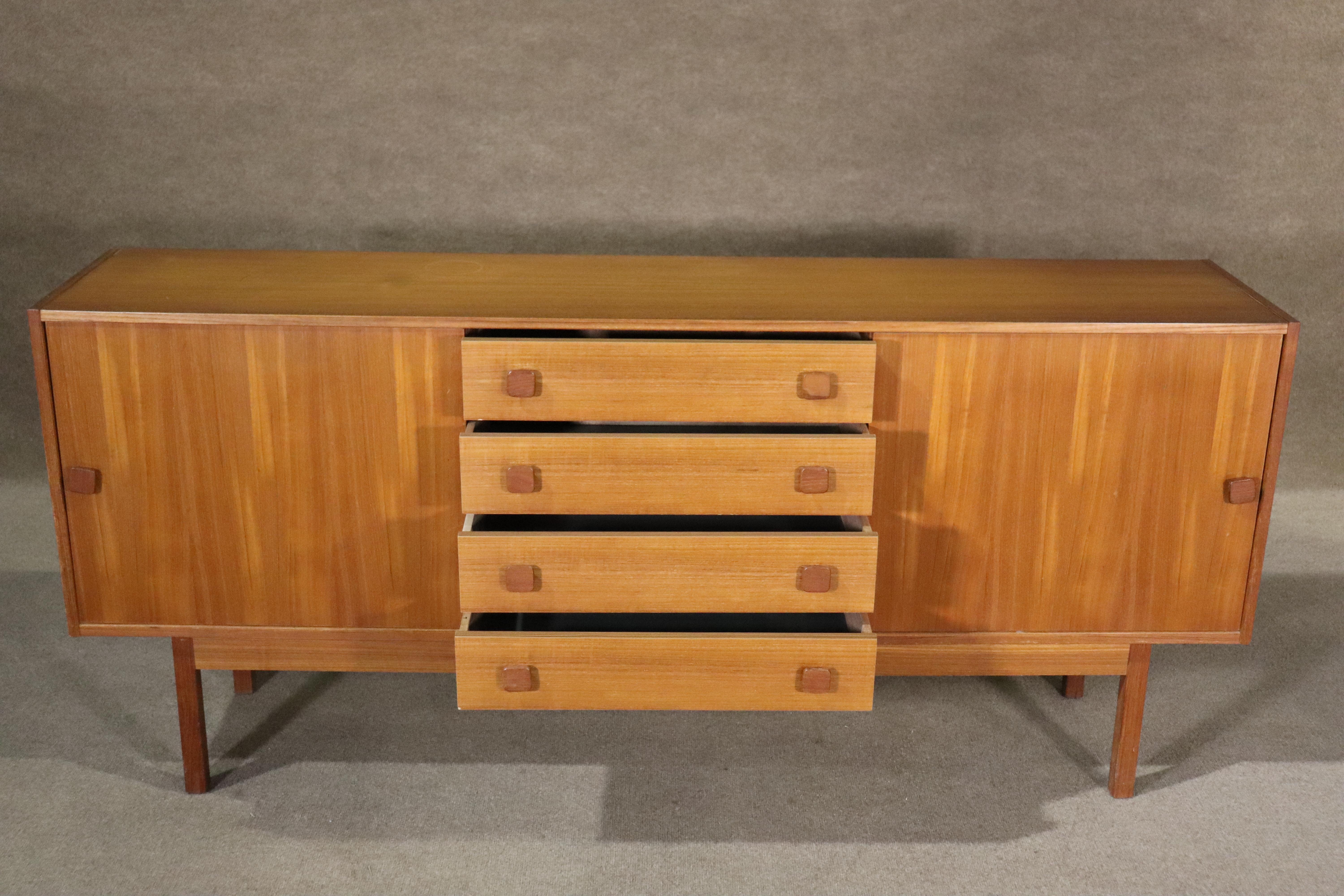 Danish made credenza in teak wood with sliding doors and center drawer storage.
Please confirm location NY or NJ