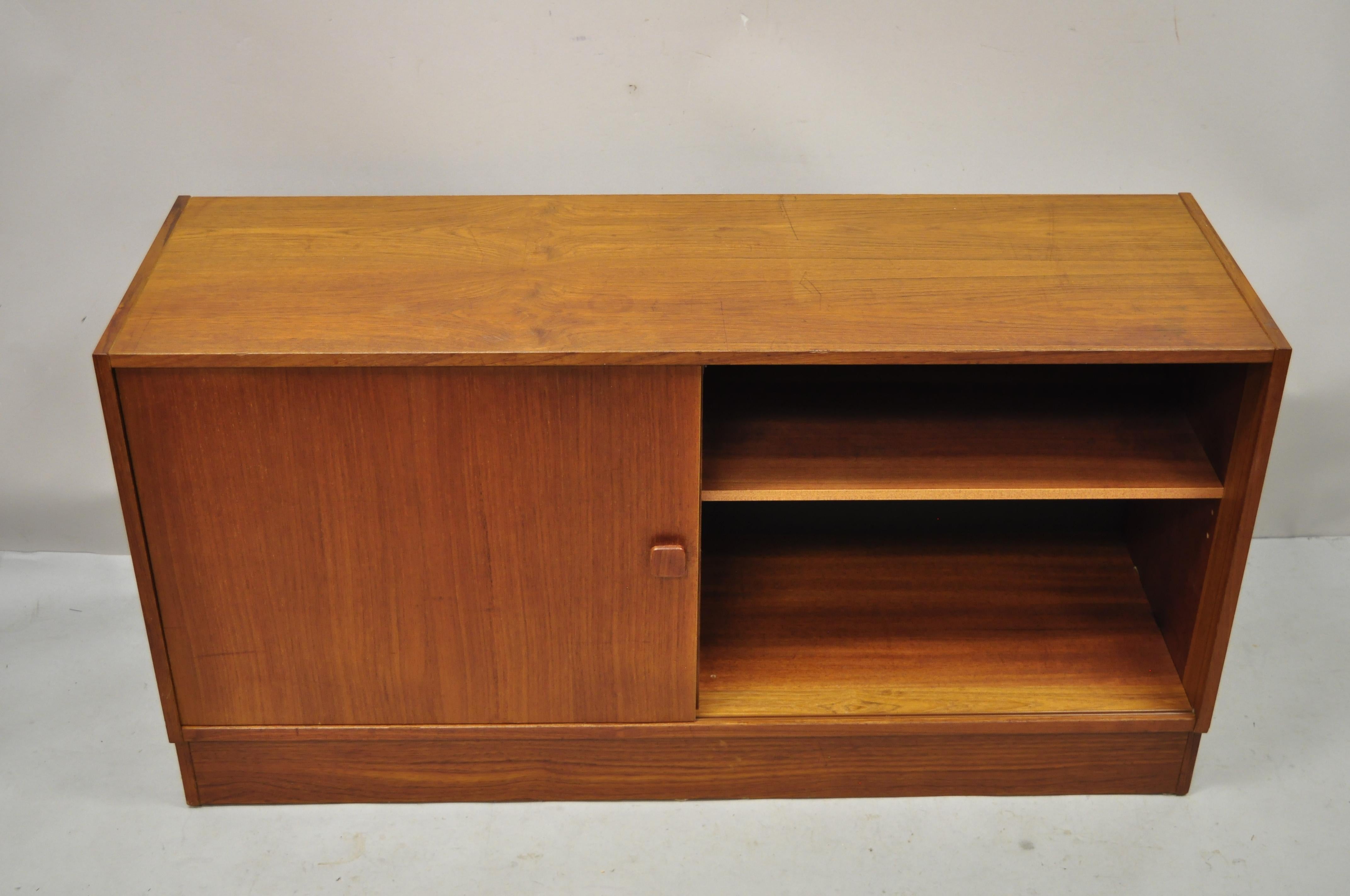 Domino Mobler Mid Century Danish Modern teak wood small credenza cabinet. Item features sliding door, beautiful wood grain, original label, 4 dovetailed drawers, clean modernist lines, great style and form. Circa mid 20th century. Measurements: 25