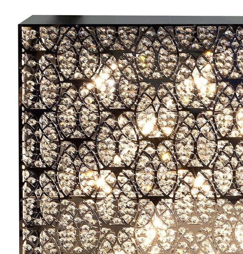 Enclosed in a rigorous silhouette, the curved steel elements that make up the shade of this magnificent wall lamp create a dynamic effect of rare sophistication. The presence of hand-applied multifaceted Asfour crystals creates an unparalleled