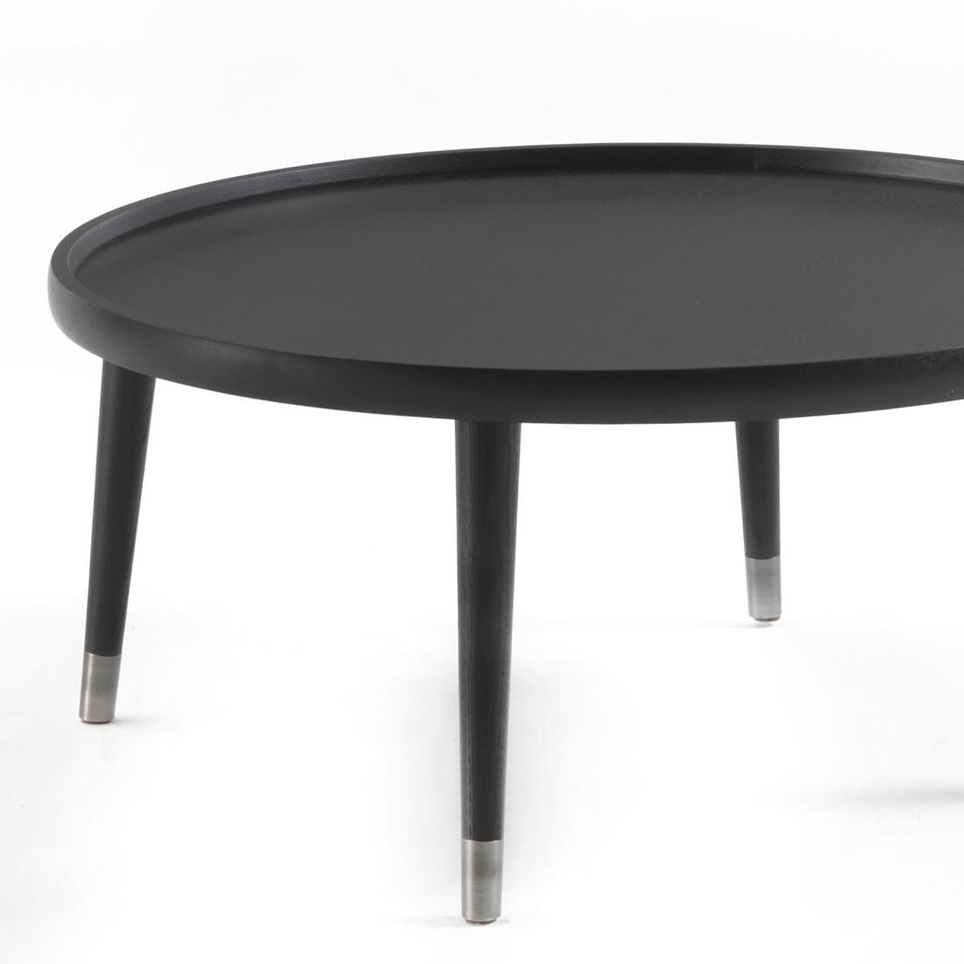 Coffee table domio wood with solid ash structure 
and roud top in black finish. With metal parts on feet.