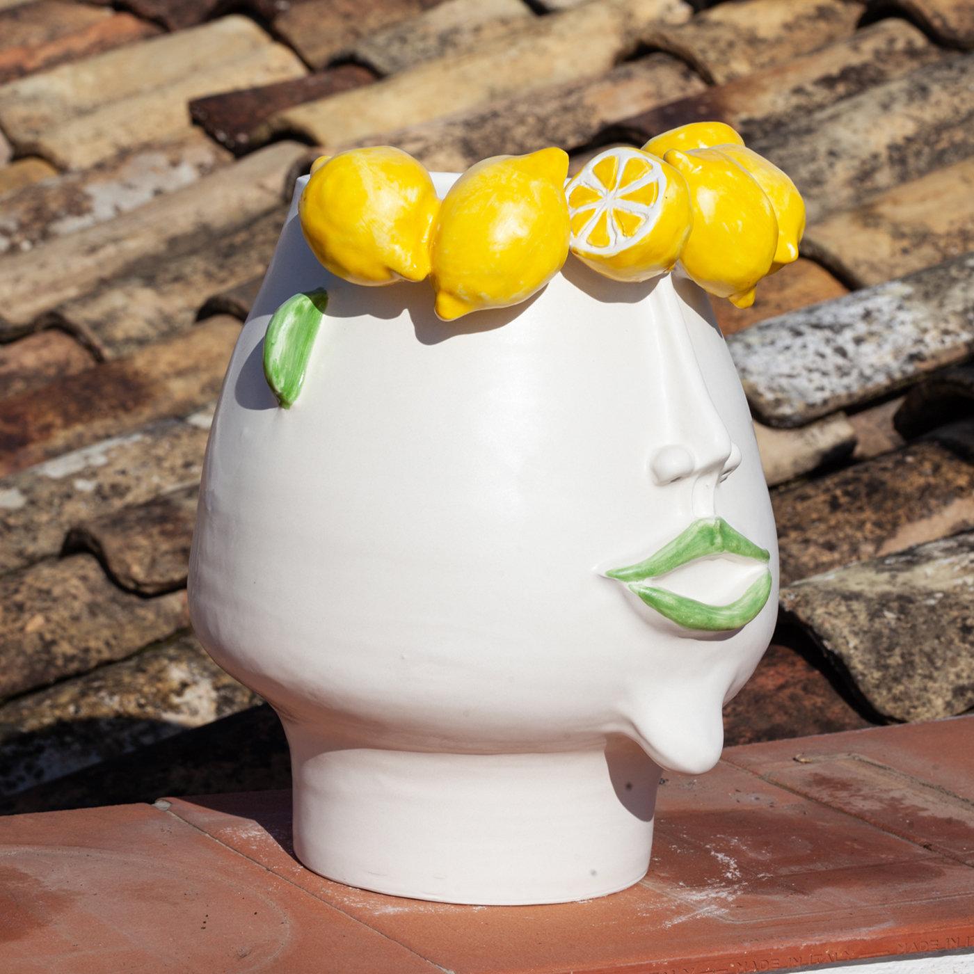 This exclusive head-shaped vase in fine white ceramic celebrates the authentic beauty of an hard yet fascinating job, the lemon picker. Ideal as vessel for both indoor or outdoor use, it depicts Domitilla, a Sicilian female lemon picker whose