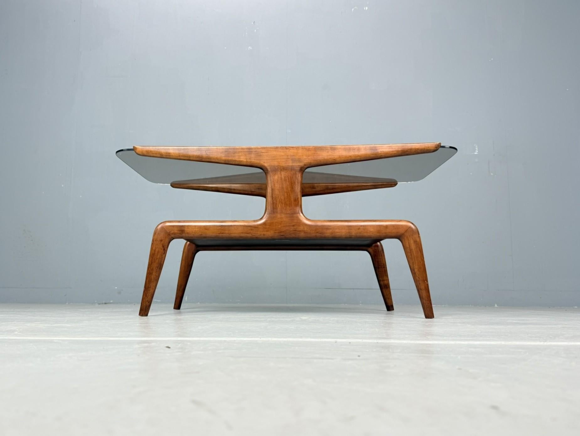 Very elegant and sculptural Domus Nova coffee table, designed by Gio Ponti and manufactured by Domus Nova for the department store La Rinascente, Italy, 1950.
The table is crafted from walnut wood with a smoked-glass top and features a distinctive