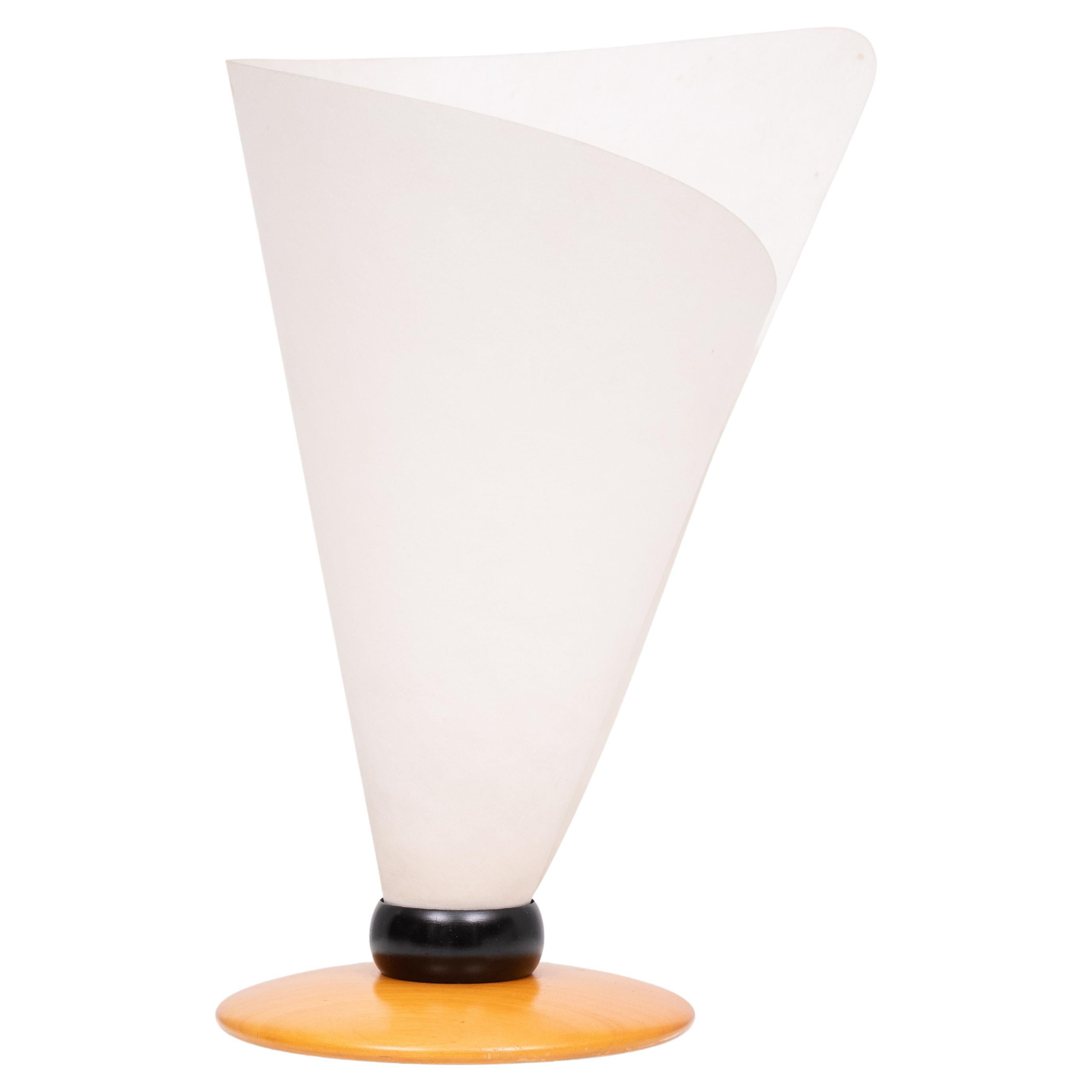 The warm Lunopal flare emphasizes the fine wooden lamp foot. The rolling shade is brought into form by two buttons and held in shape by a ring of Black finished aluminium. The lamp comes with  cable with a hand switch.

