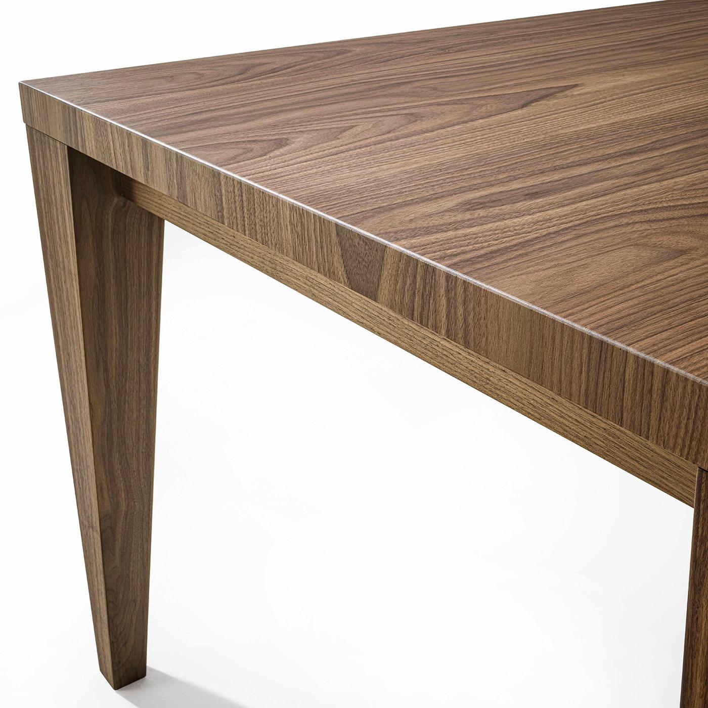 Prized Canaletto walnut with its intriguing, warm, and unpredictable traceries was chosen to counterbalance the unadorned design of this dining table. Distinguished by solid tapered legs emphasizing its sharp lines, it will effortlessly complement a
