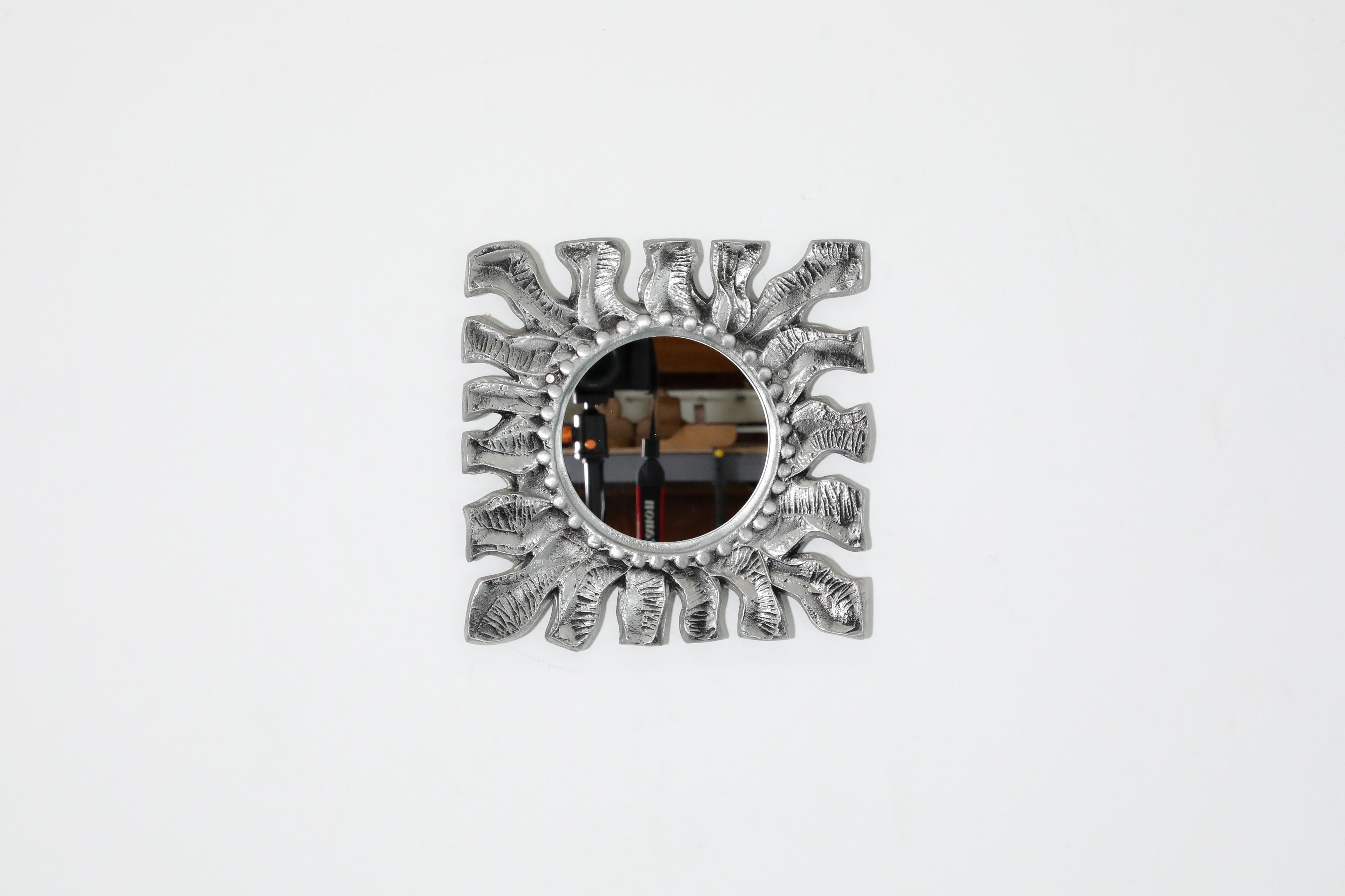 Schöner Sonnenspiegel aus Aluminiumguss von Donald Drumm, 1970er Jahre. Der geprägte, strukturierte Aluminiumrahmen mit organischen Kurven und rundem Spiegel ist eine dekorative Ergänzung mit stilvoller Funktionalität. In ursprünglichem Zustand mit