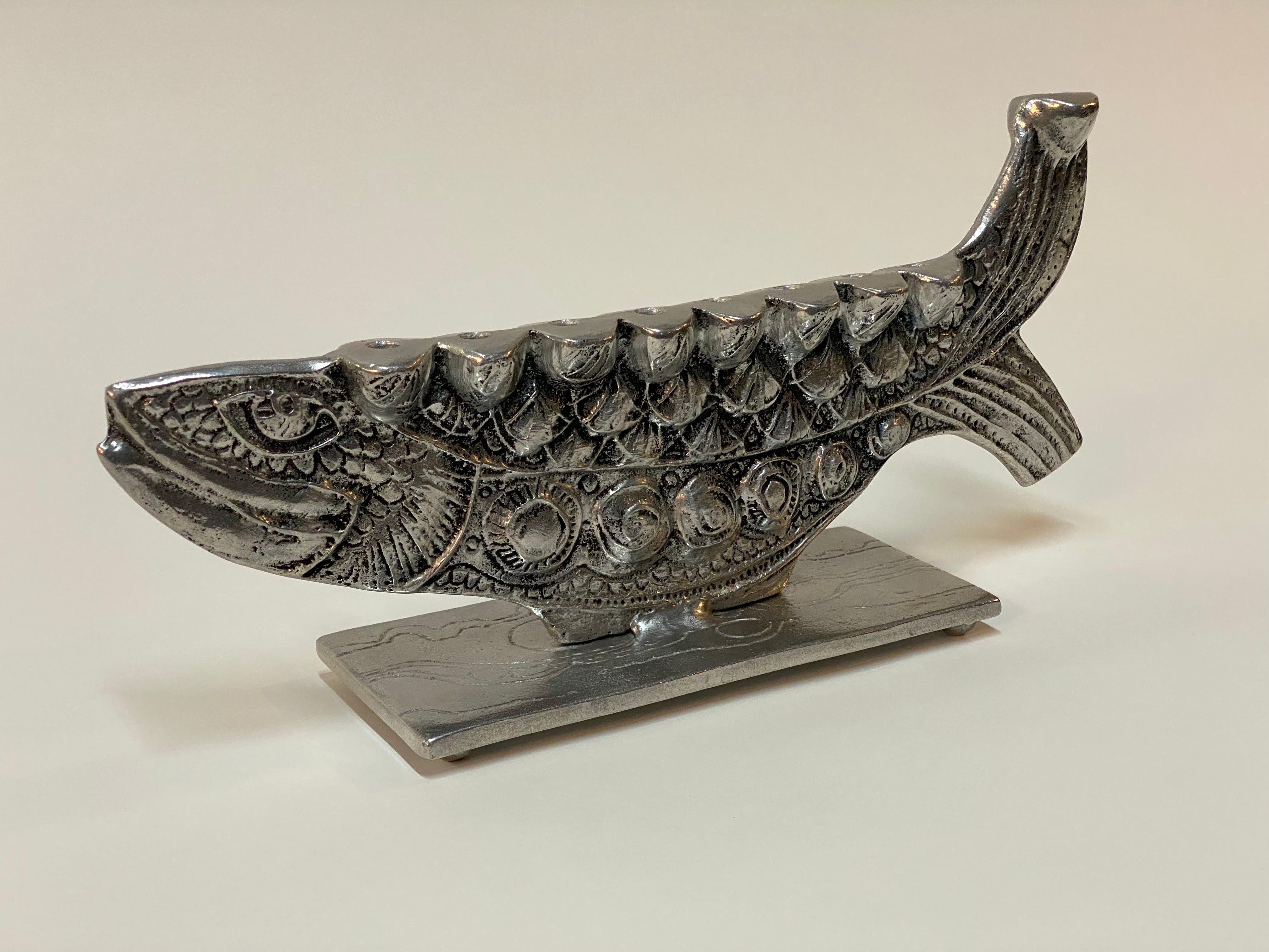 Don Drumm cast aluminum figural fish Menorah. Wonderfully cast detailed brutalist fish. The menorah holds nine skinny tapered candles for Channukah. Signed on the bottom, Drumm. Good condition with no major visible conditions. Wear consistent with