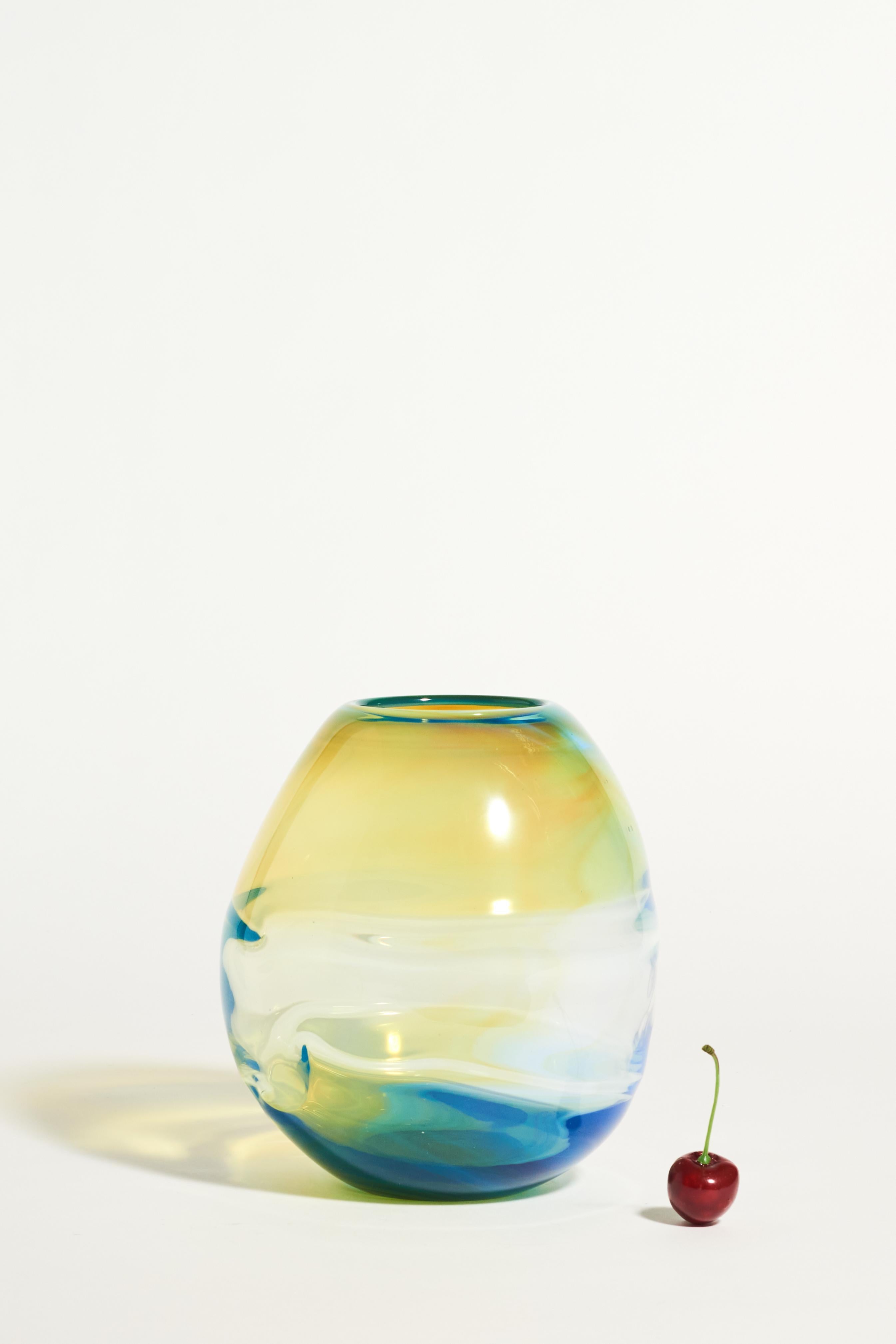 Beautiful conical vase by glass artist Don Gonzalez, layered swirls of soft yellows, blues and clear glass, signature on base.