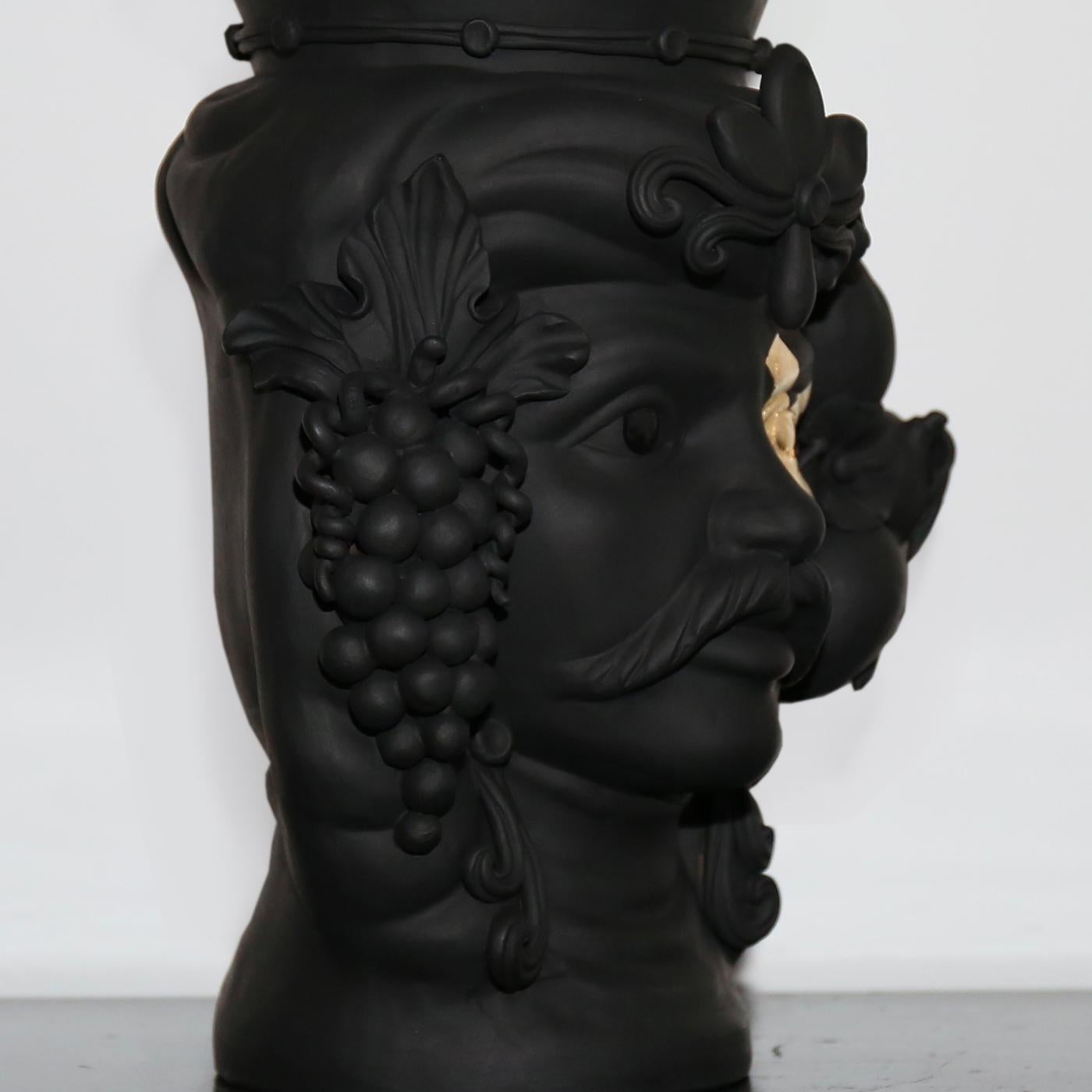 Pièce de décoration fonctionnelle remarquable, ce vase anthropomorphe représentant un Maure témoigne de la richesse de l'histoire artisanale et du patrimoine artistique de la Sicile. Entièrement réalisée à la main et finie avec une glaçure noire