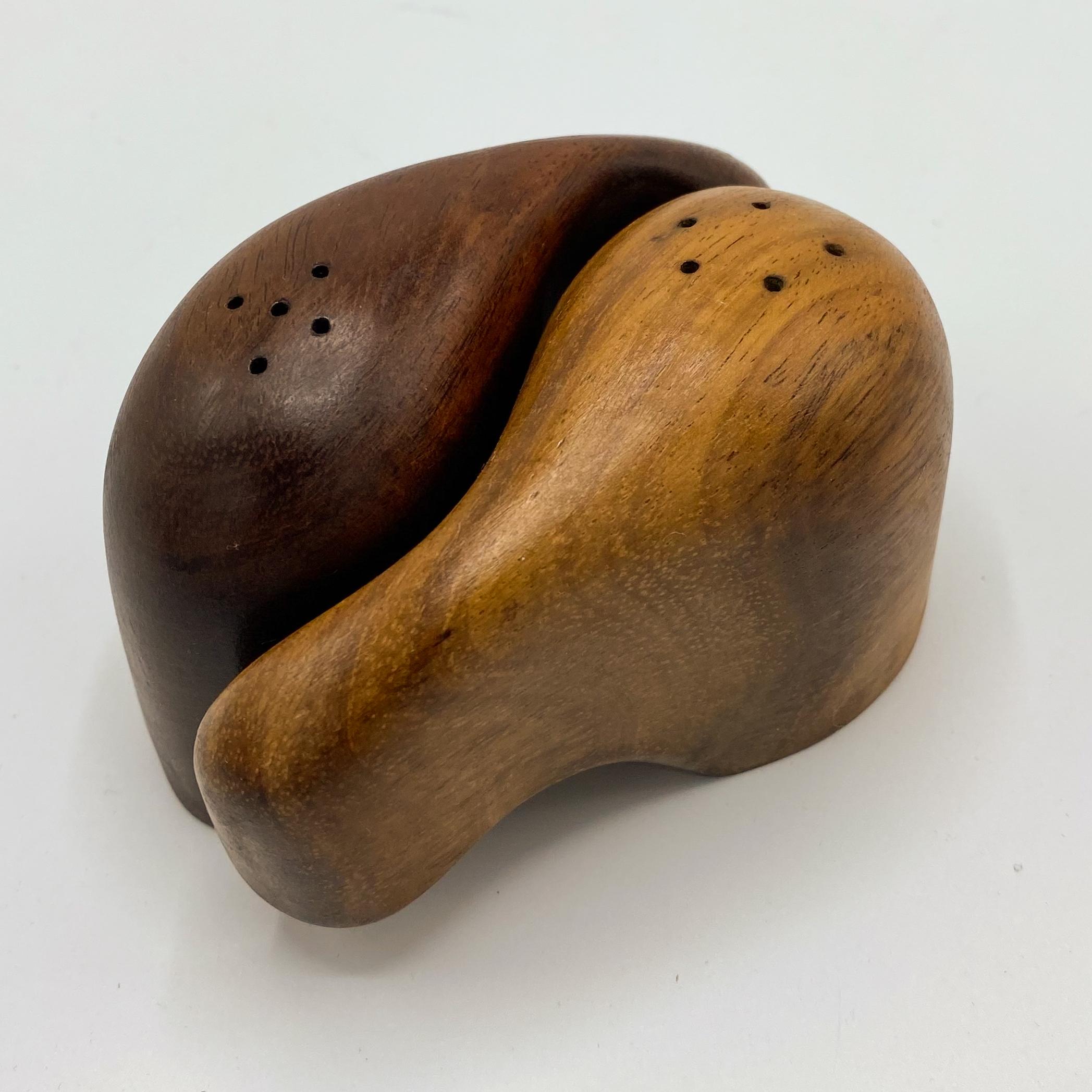 Nesting salt and pepper shakers handcrafted of Cocobolo wood by Don Shoemaker of Senal, Mexico, circa 1970s. Shoemaker was an American expat who set up an artisan atelier in the hinterlands of Mexico in the 1950s, employing local exotic woods and