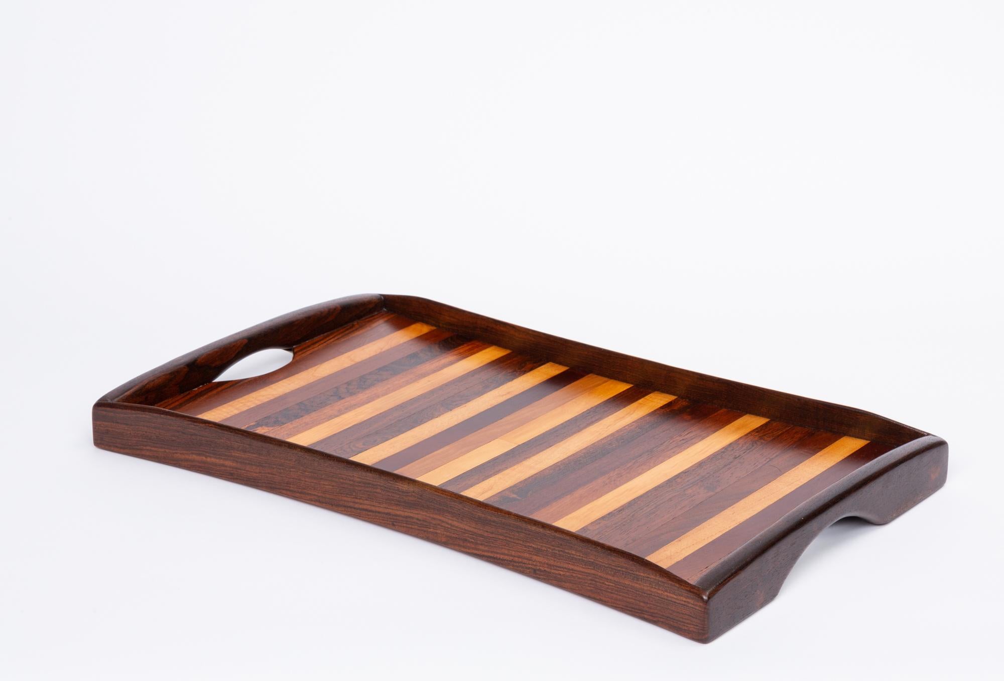 Rosewood tray by Don Shoemaker for Señal, designed and produced in Mexico. This examples have slightly bowed edges framed by four curved pieces of solid rosewood. There is a cut-out handle on either side of the tray. The surface features an inlay