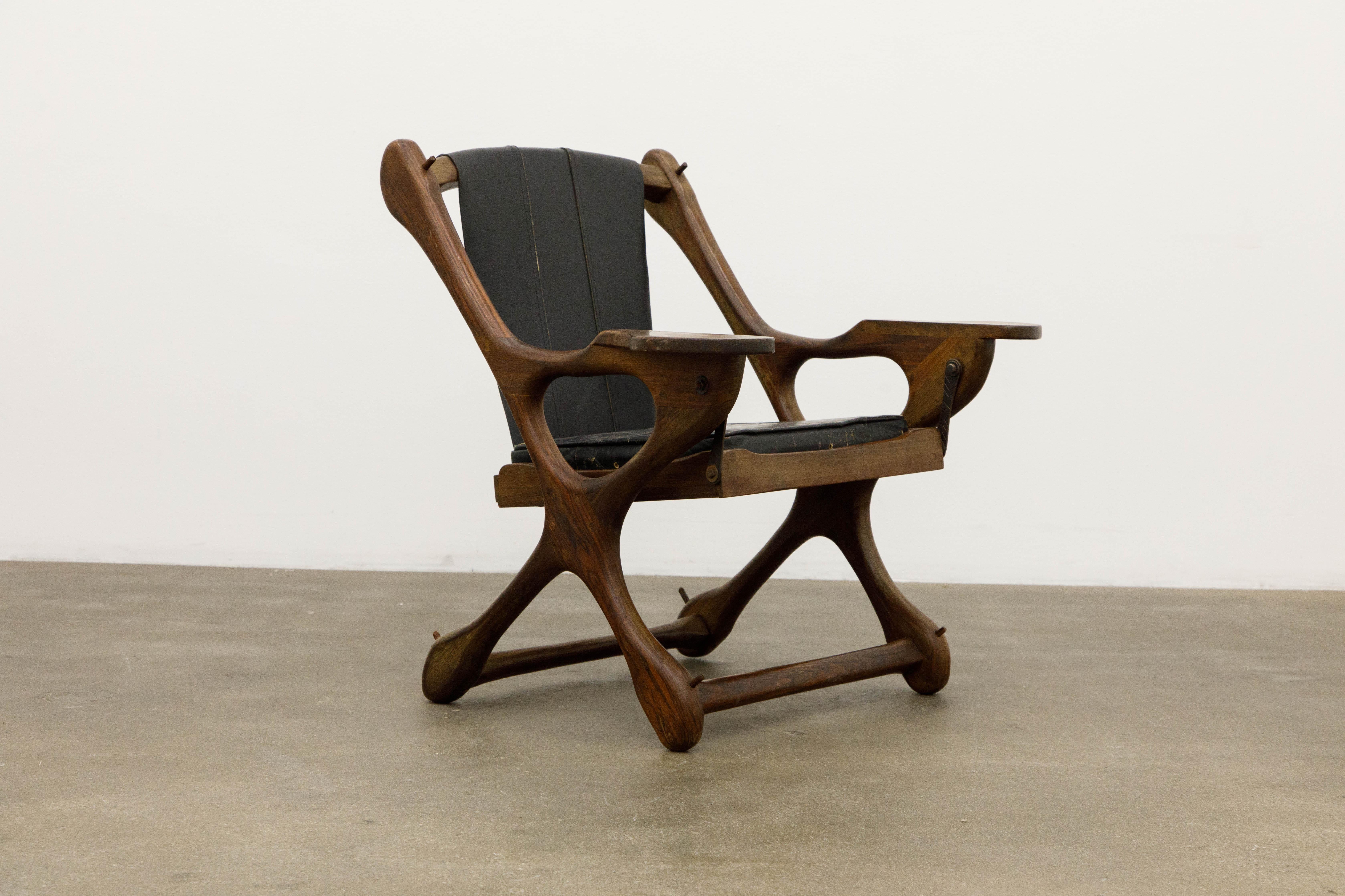 Named the 'Swinger Chair' for its pivoting mechanism that allows you to swing in your seat, this incredible cocobolo rosewood and black leather 'Swinger' rocking armchair by leading 1960s modernist designer Don Shoemaker for Senal S.A. (Mexico) is