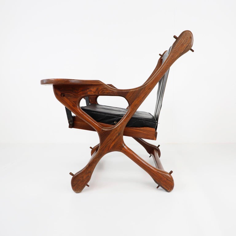 Circa 1960, We offer this 'Swinger Chair' named for its pivoting mechanism that allows you to swing in your seat, this incredible Cocobolo Rosewood and black leather 'Swinger' chair with matching ottoman by leading 1960s modernist designer Don