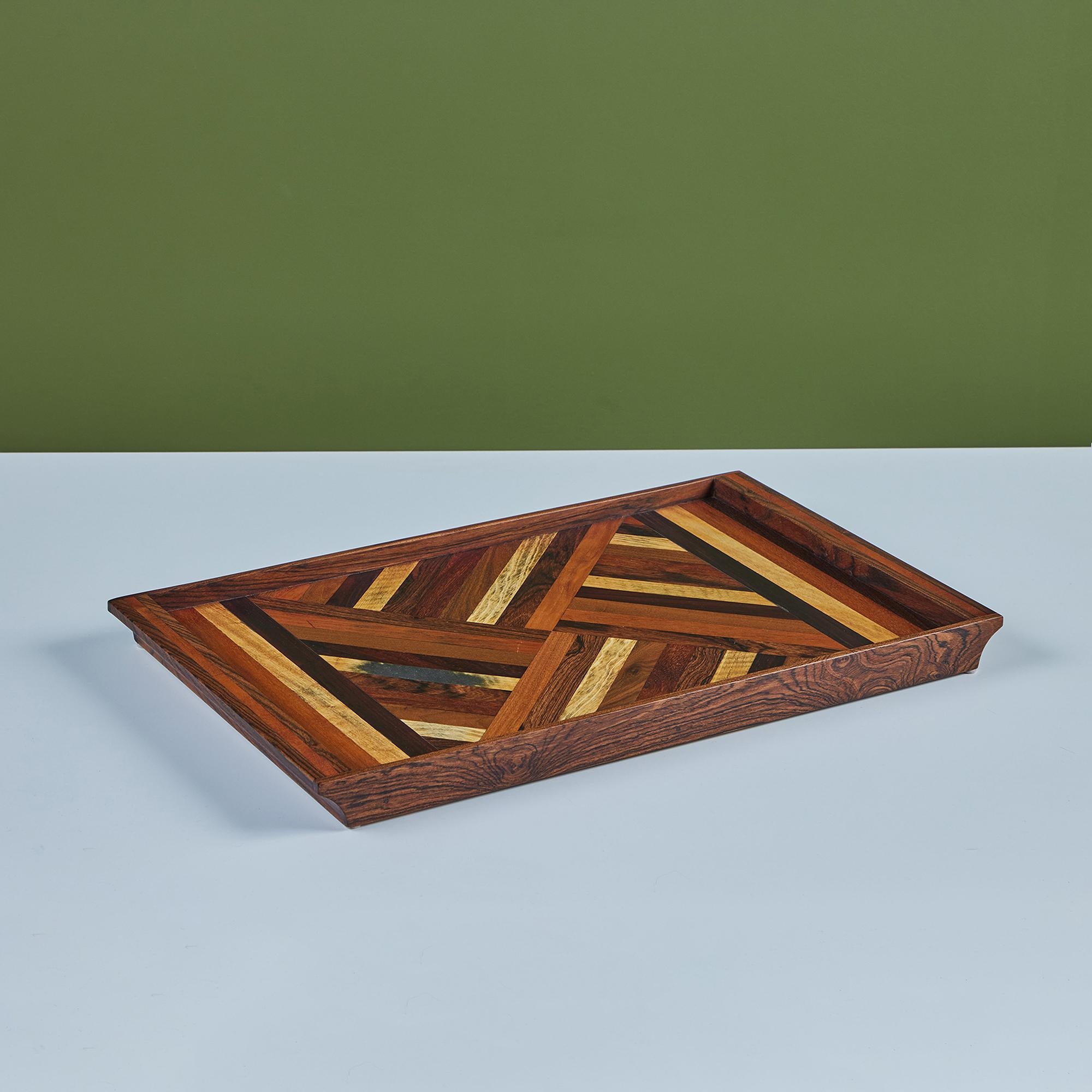 A rosewood serving tray by Don Shoemaker for his company Señal in the 1960s. The surface of the tray has a repeating geometric marquetry pattern in a gradient of local Mexican hardwoods. The rectangular tray has four sides and two handles.

CITES