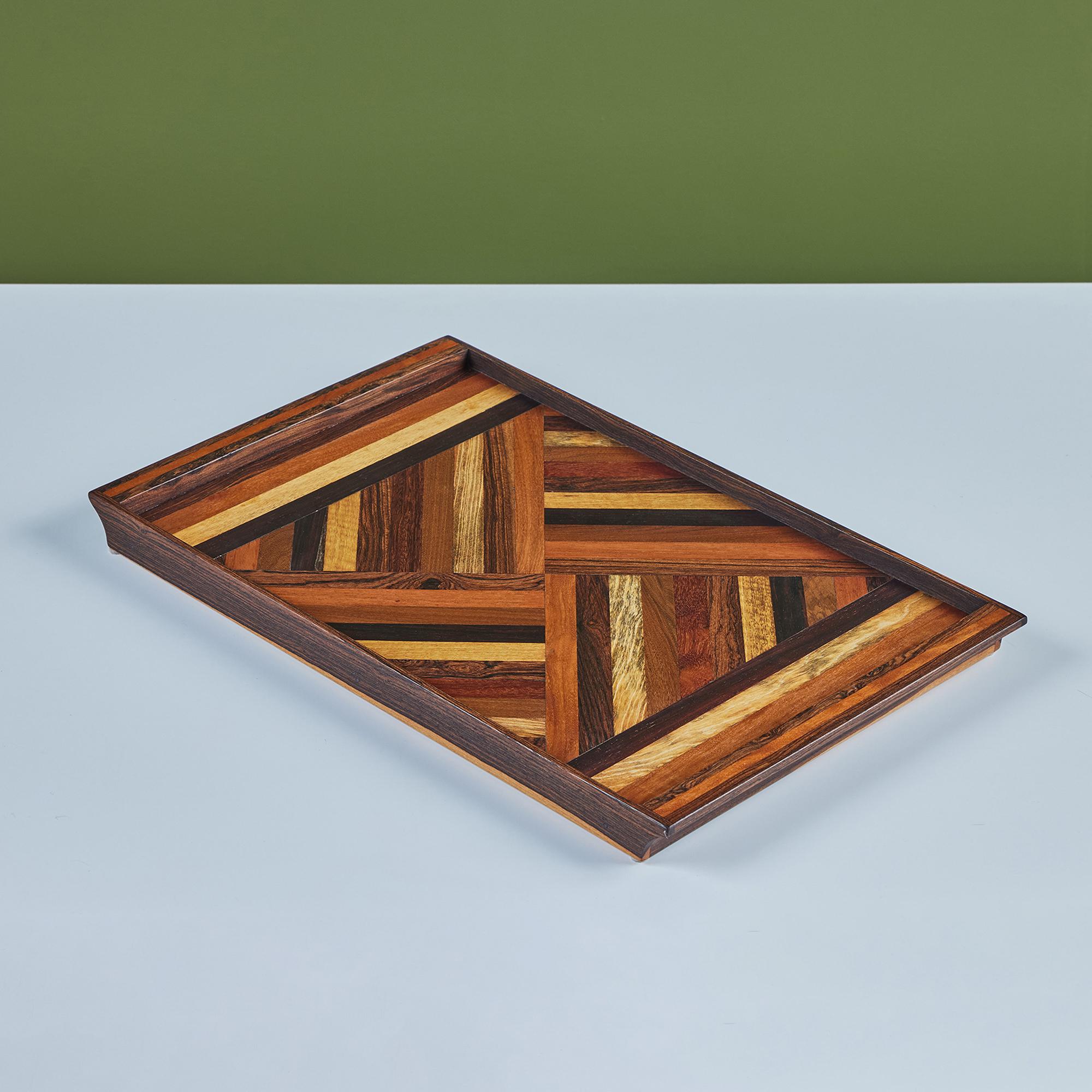 A rosewood serving tray by Don Shoemaker for his company Señal in the 1960s. The surface of the tray has a repeating geometric marquetry pattern in a gradient of local Mexican hardwoods. The rectangular tray has four sides and two handles.

CITES