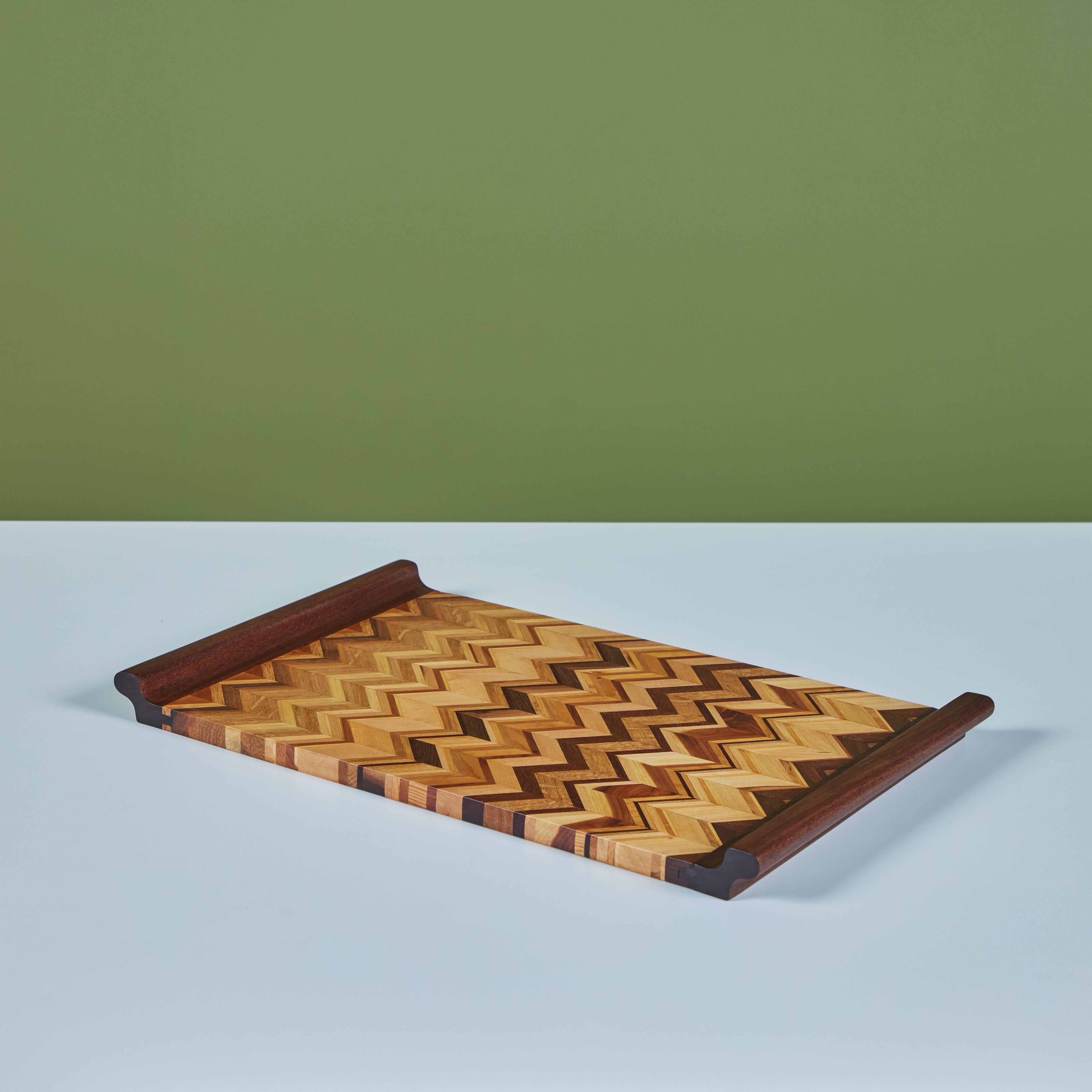 A rosewood serving tray by Don Shoemaker for his company Señal in the 1960s. The surface of the tray has a repeating geometric linear marquetry pattern in a gradient of local Mexican hardwoods. The rectangular tray has two handles and exposed sides