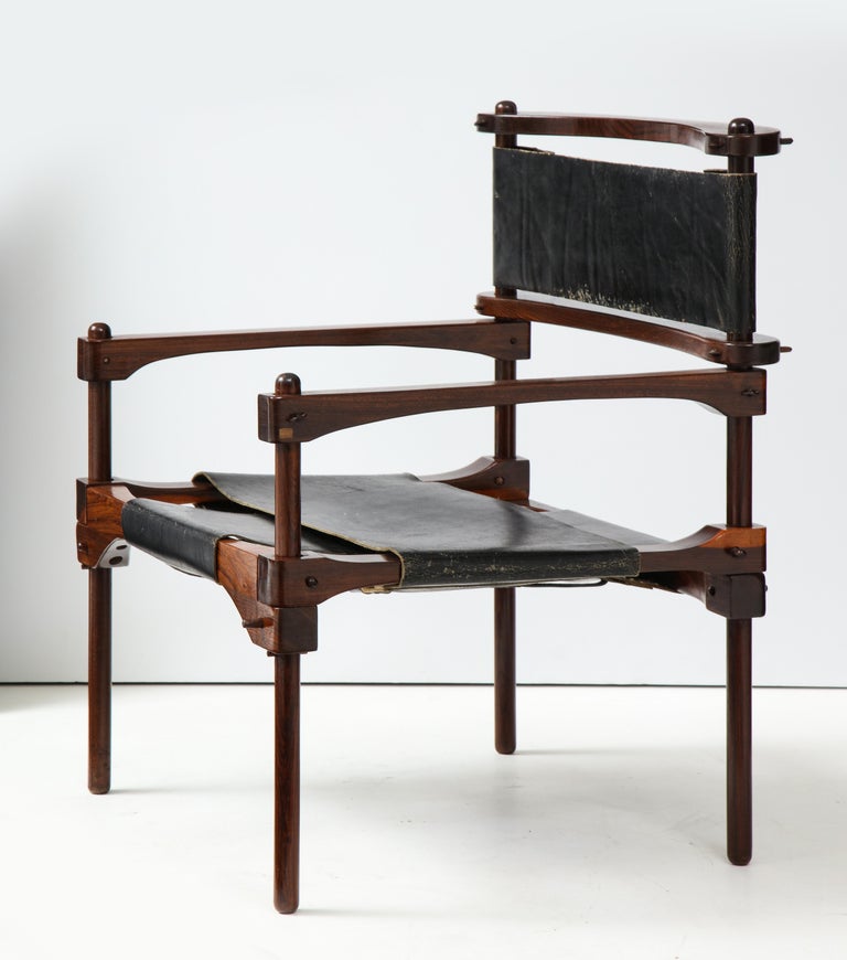 Perno safari chair of exotic Cocobolo wood with original black saddle leather slings, designed by American expat Don Shoemaker and produced at his Senal Studios in Mexico circa 1960's. A rare Shoemaker entry with an elegant Constructivist mien, this