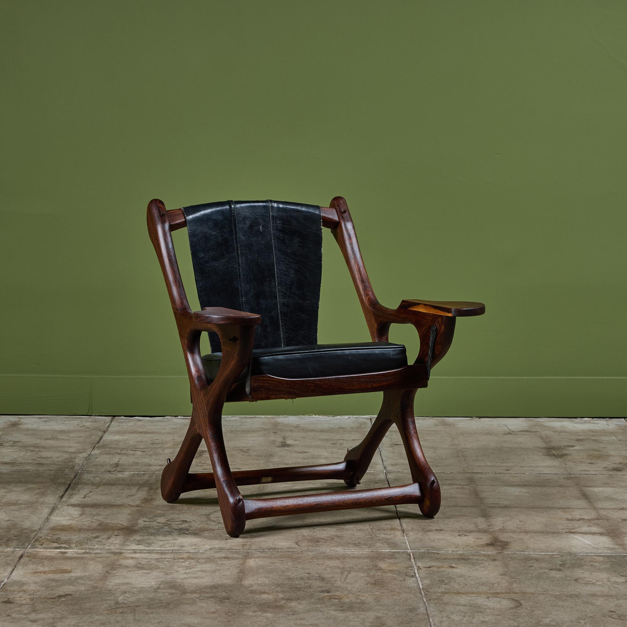 Leather lounge chair by Don Shoemaker for Señal, c.1960s, Mexico. The chair features a rosewood frame and original black leather hide. Nail details line the top of the seat back of the chair. The chair has a cushioned seat the swings, coining its