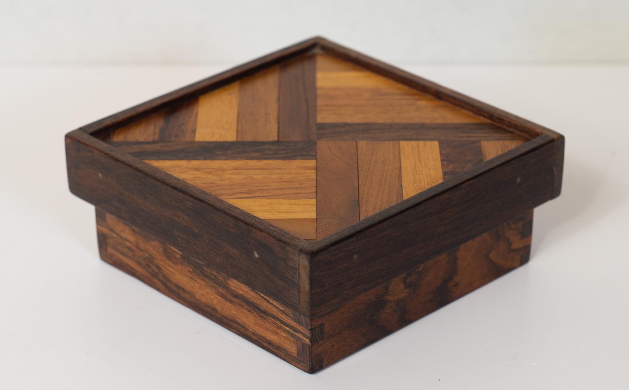 Designed by eccentric woodworker and designer Don Shoemaker, this trinket box was made by Senal in Mexico. It employs a cacophany of exotic woods, including cocobolo, jacaranda, and mahogany laid into a case of solid rosewood. The look is dramatic,
