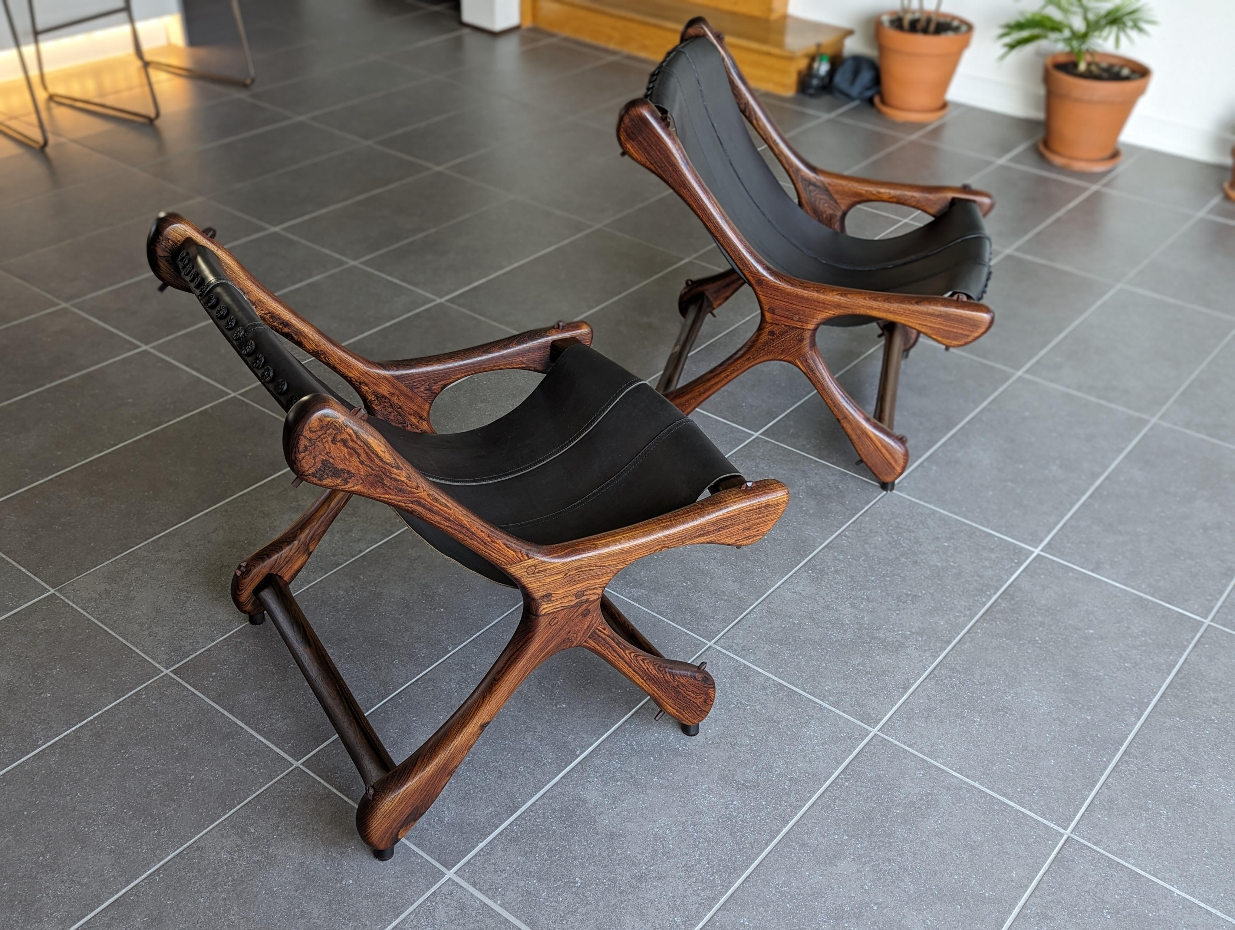 For your consideration, a pair of 1960s Don Shoemaker Sloucher lounge chairs, in solid cocobolo rosewood and black leather. Iconic example of Organic, Mexican Mid-Century Modern design. 

Organic, bone-like shapes and structure, with solid cocobolo