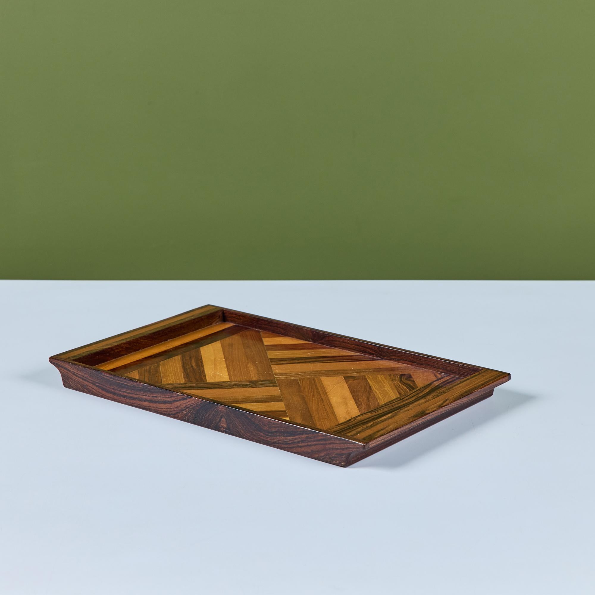 Plateau de service en bois de rose réalisé par Don Shoemaker pour sa société Señal dans les années 1960. La surface du plateau présente un motif géométrique répétitif de marqueterie dans un dégradé de bois durs mexicains locaux. Le plateau