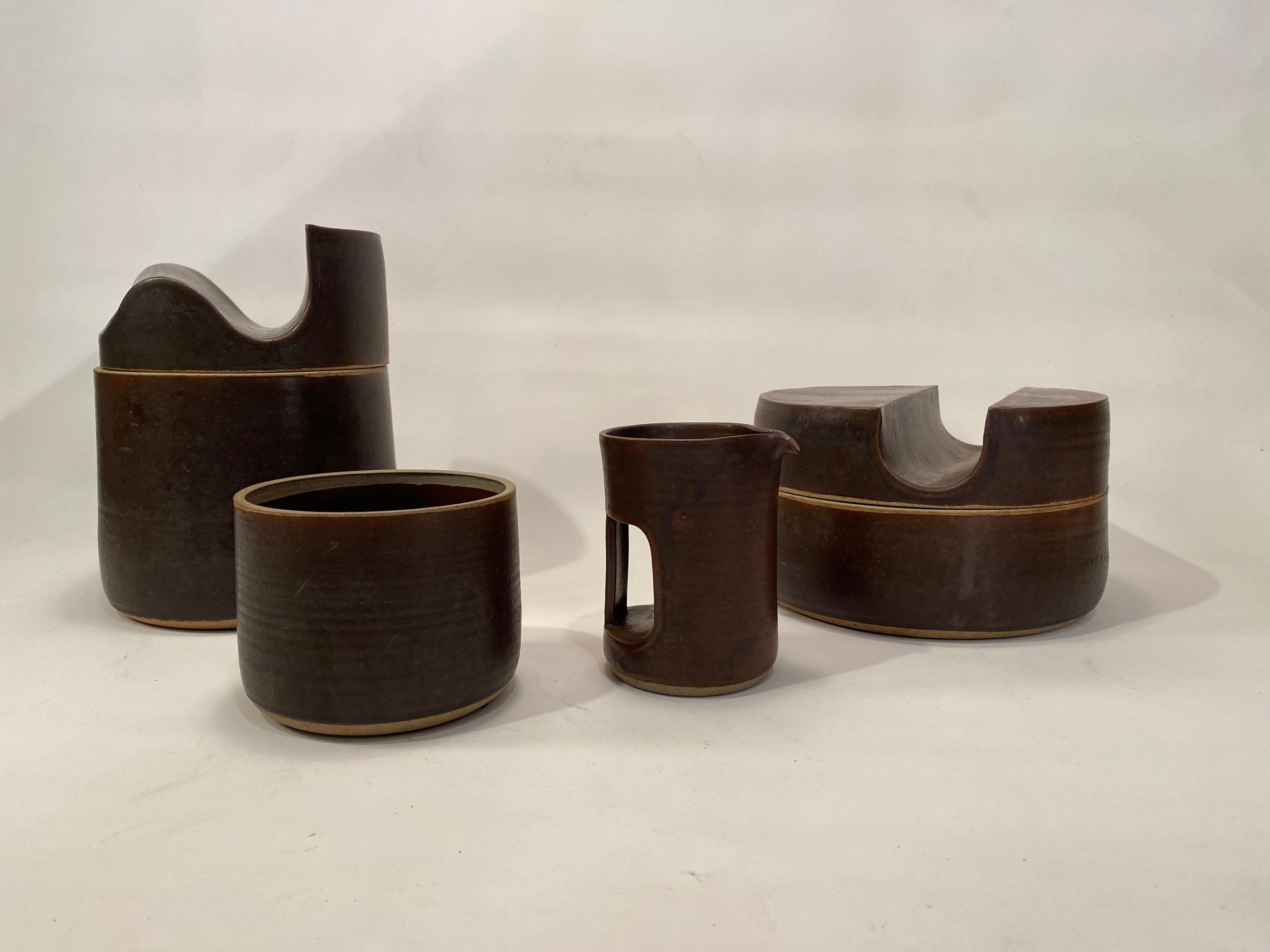 Four wonderfully executed matte brown drip glazed architectural pottery pieces by master potter, Don Williams. The ever productive and creative Don Williams can be viewed at donwilliamsclay. The grouping is comprised of two lidded vessels, a small