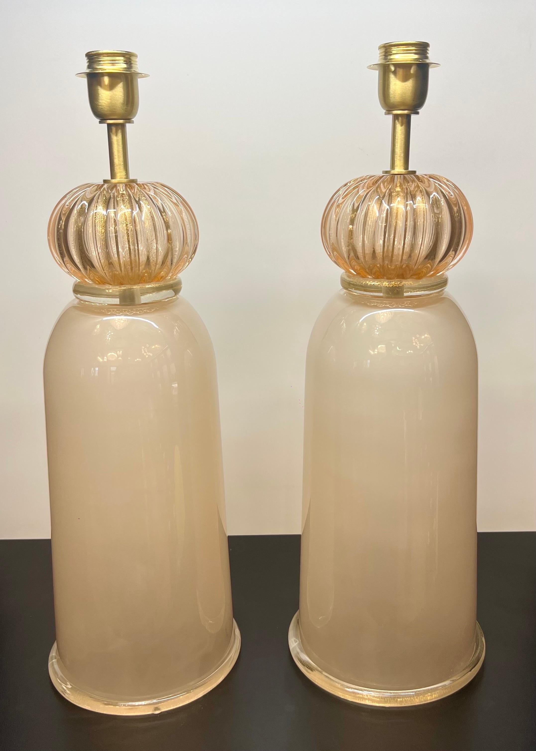 Esclusiva coppia di lampade da tavolo in vetro di Murano Rubin con struttura in bronzo satinato.
La lampada è composta da 1 elemento a forma di cipolla con oro a 24 carati e 1 elemento a forma di birillo.
Toccando con la mano l'elemento a forma di