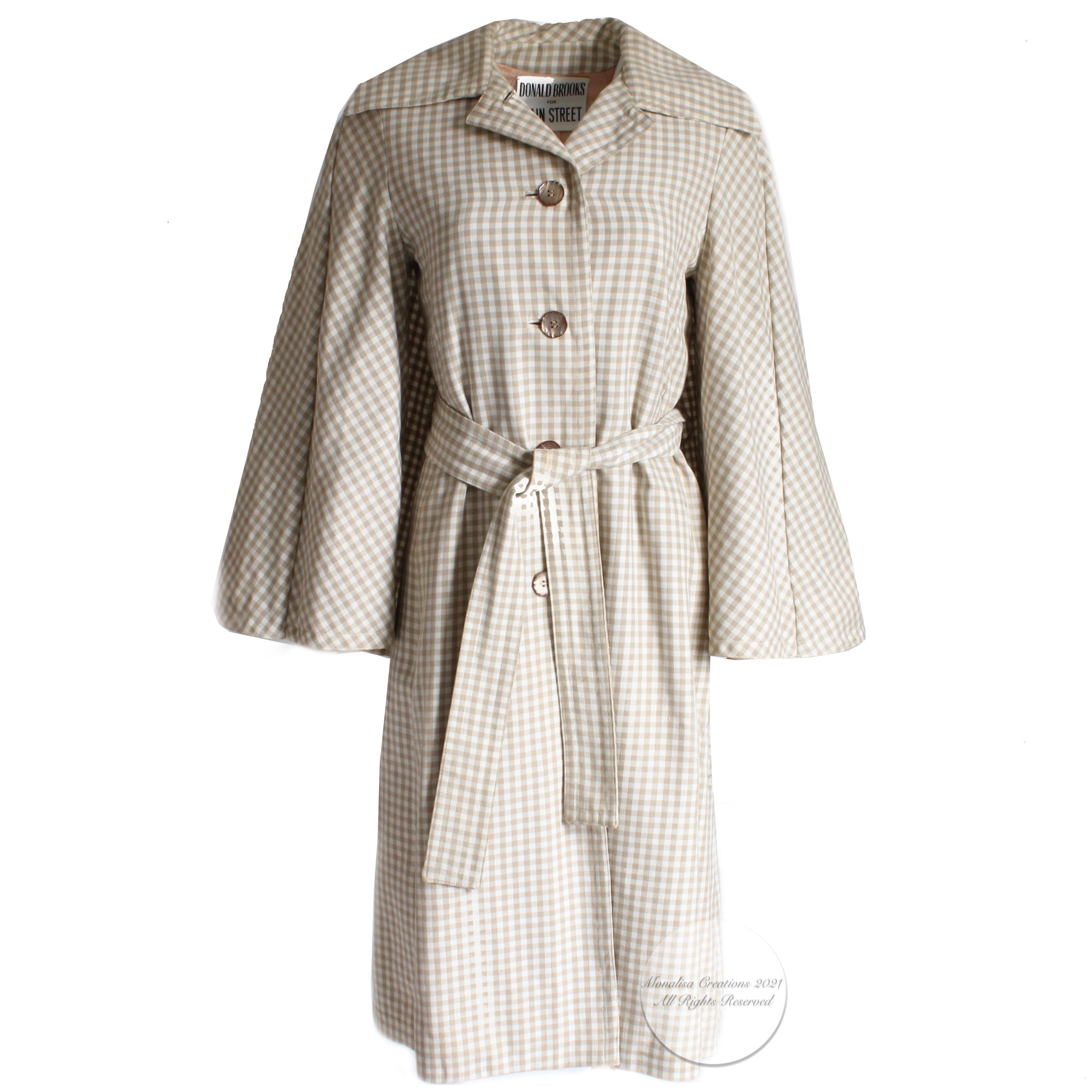 Authentic, preowned, vintage Donald Brooks trench style coat or jacket with attached caplet/cape, circa the 70s. Tan and white check fabric/coat is lined/dry clean recommended/no fabric label (feels like light wool).  Comes with detachable belt. No