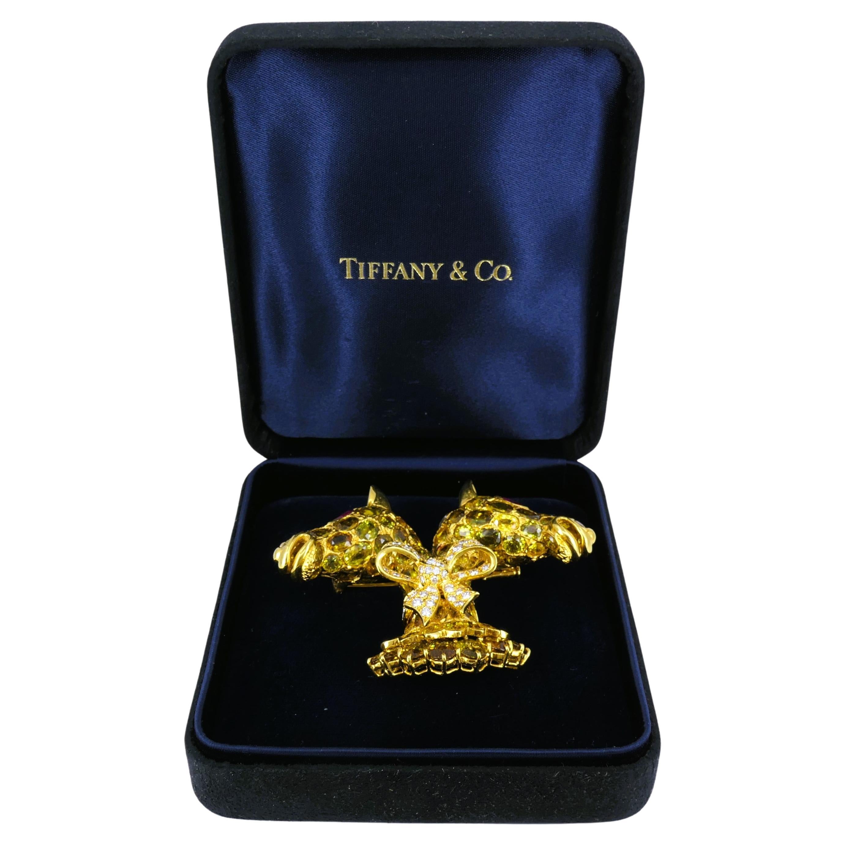 Espectacular broche de Donald Claflin, de oro de 18 quilates, con piedras preciosas de colores y diamantes.
El broche está diseñado como dos cabezas de jirafa con un cuello decorado con un lazo de diamantes. El broche está totalmente sembrado de