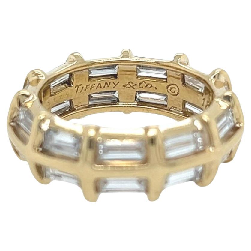An 18 karat yellow gold and diamond ring, Donald Claflin, Tiffany & Co.  Designed as a band set all around with two (2) rows of eleven (11) horizontally set baguette cut diamonds separated by convex gold bars.  Total diamond weight approximately