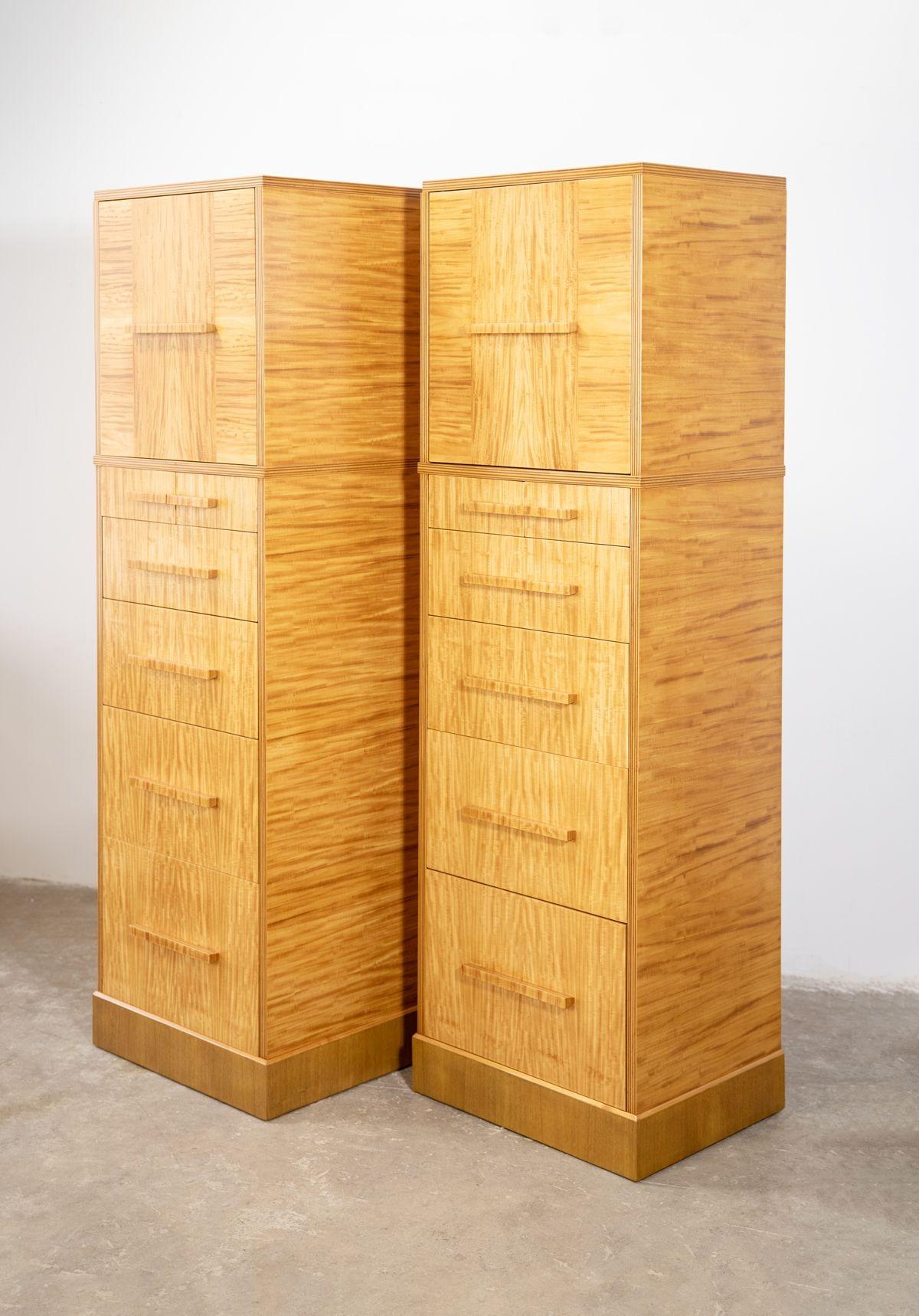 Extraordinary pair of tall skyscraper chests of drawers crafted from highly figured ribbon Avodire wood. They were constructed by the Holland Furniture Company in the 1940s. Donald Deskey at this time was also designing for the Baker furniture