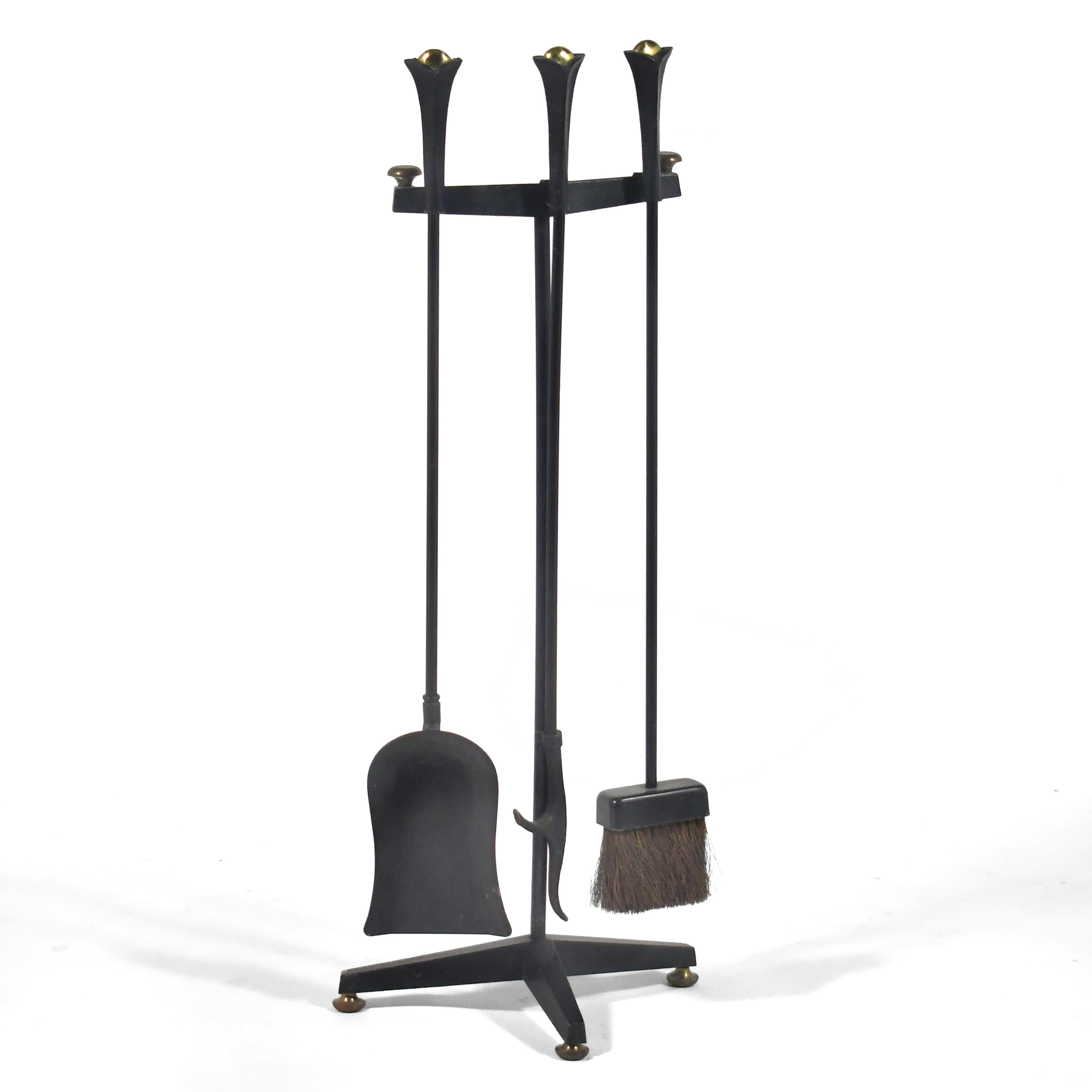 This four piece set of Donald Deskey fire tools by Bennett includes a poker, broom, shovel and stand/ holder. The black iron is accented by brass details.

33.5