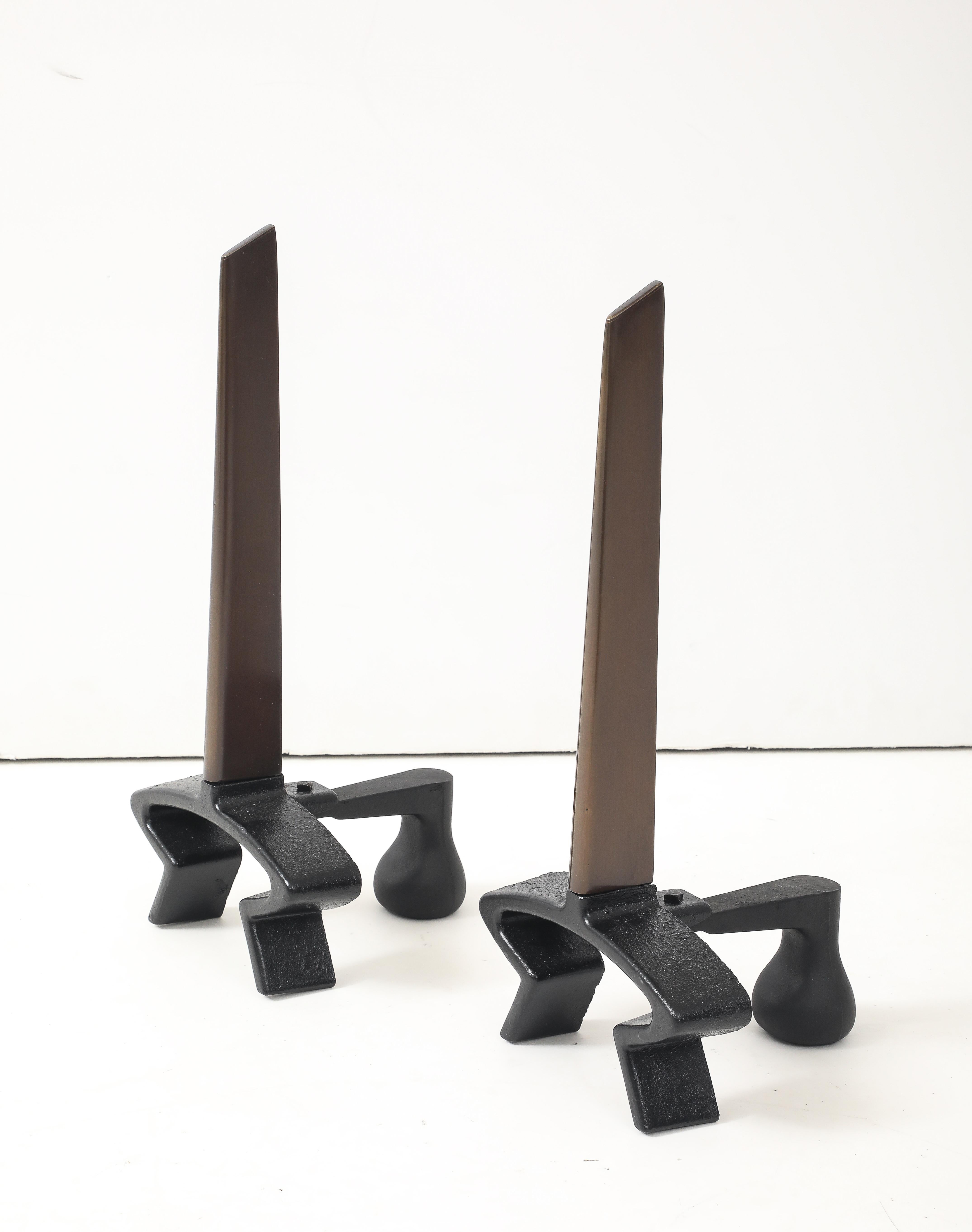 Pair of Modernist cast iron andirons featuring a bronzed blade. Donald Deskey for Bennett.
