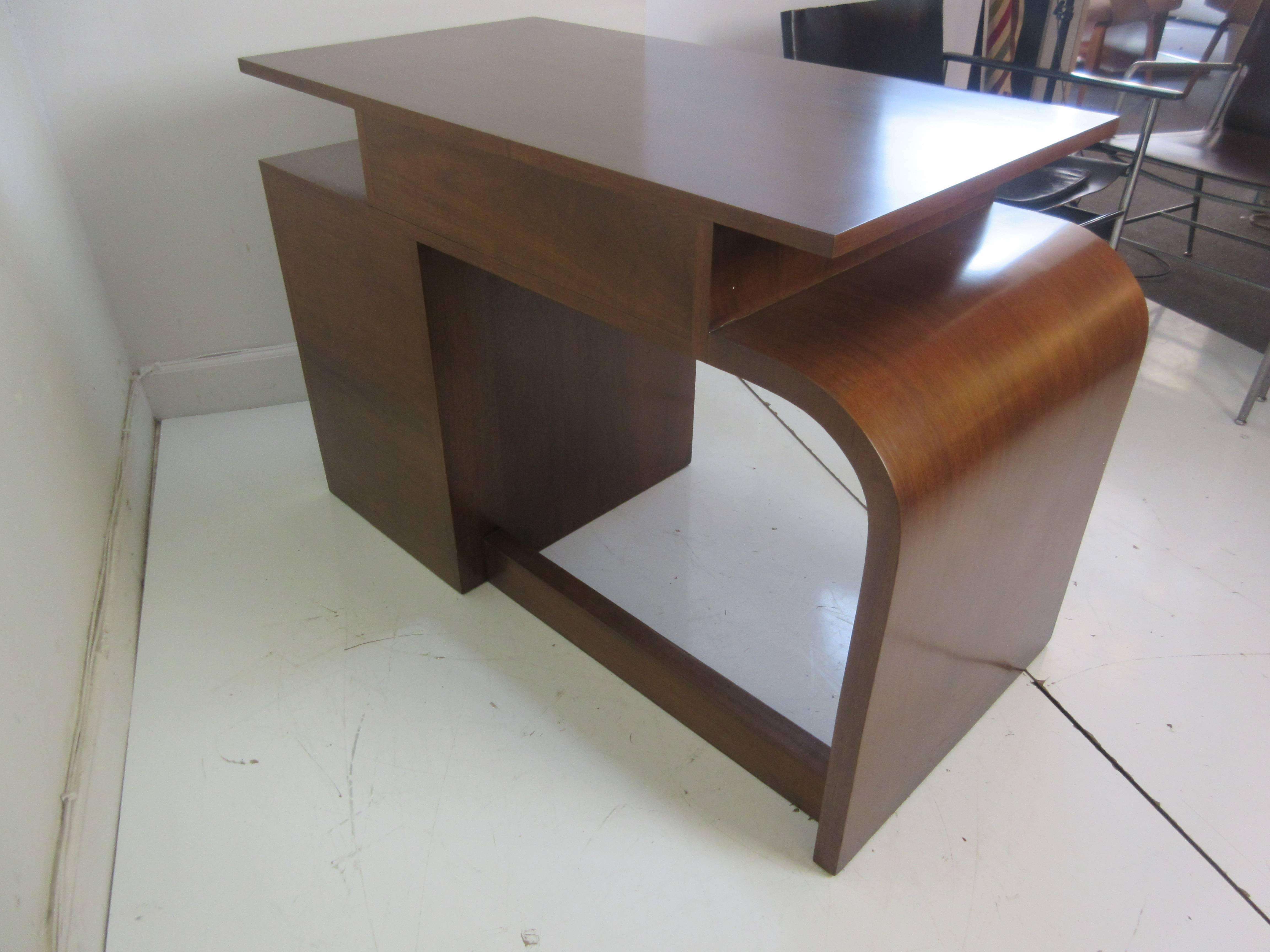 Donald Deskey for Widdicomb walnut asymmetrical desk with chrome pulls and black wood shadow pieces behind the handles. Three side drawers and one bigger top drawer. Very Unique design with a curved side leg, and open area to the right. Desk is