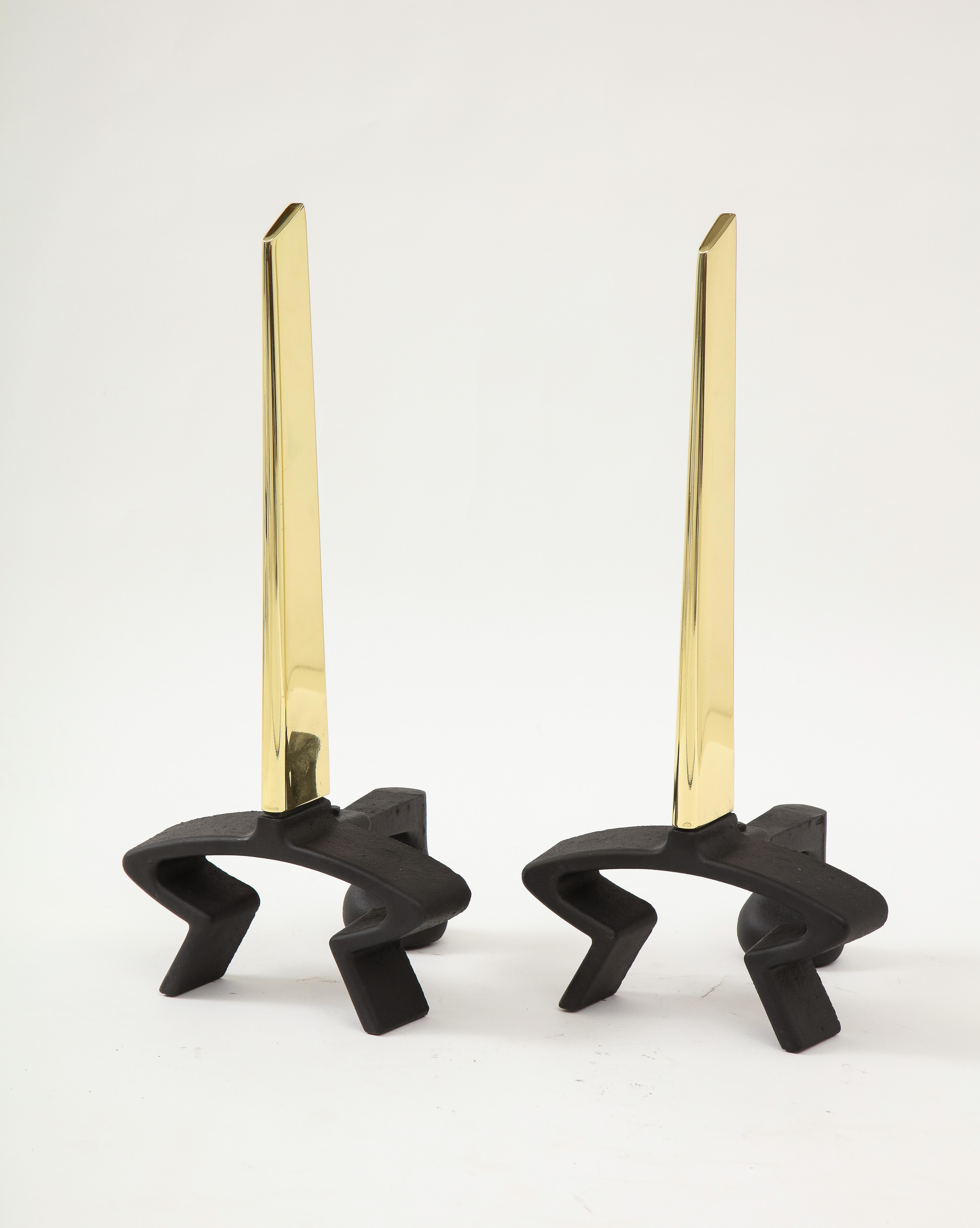 Pair of blackened iron andirons with a polished brass streamlined blade. Designed by Donald Deskey.