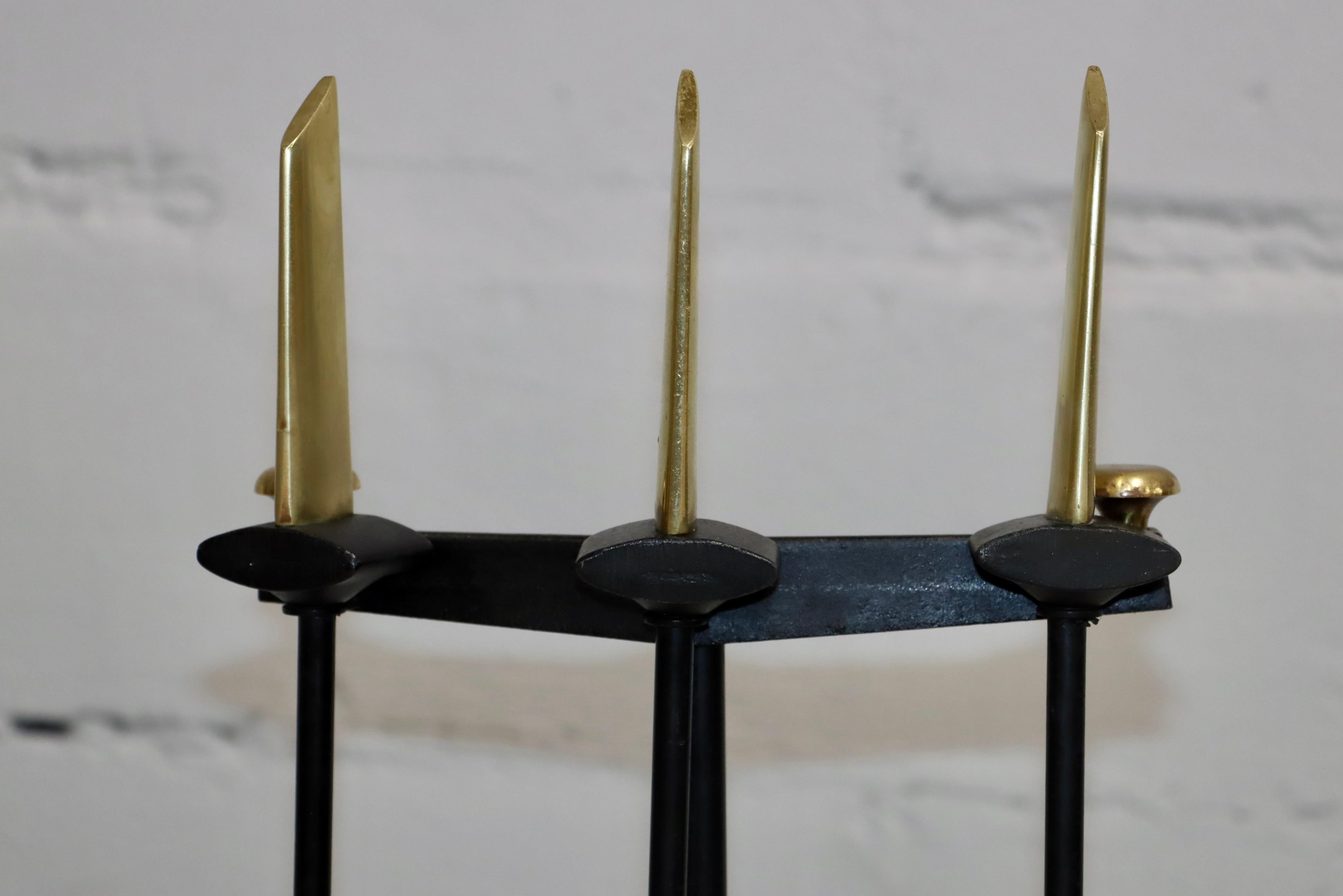 1960's mid-century modern brass and iron 3 piece fireplace tools with brass and iron tripod stand designed by Donald Deskey, in vintage original condition with some wear and patina due to age and use.