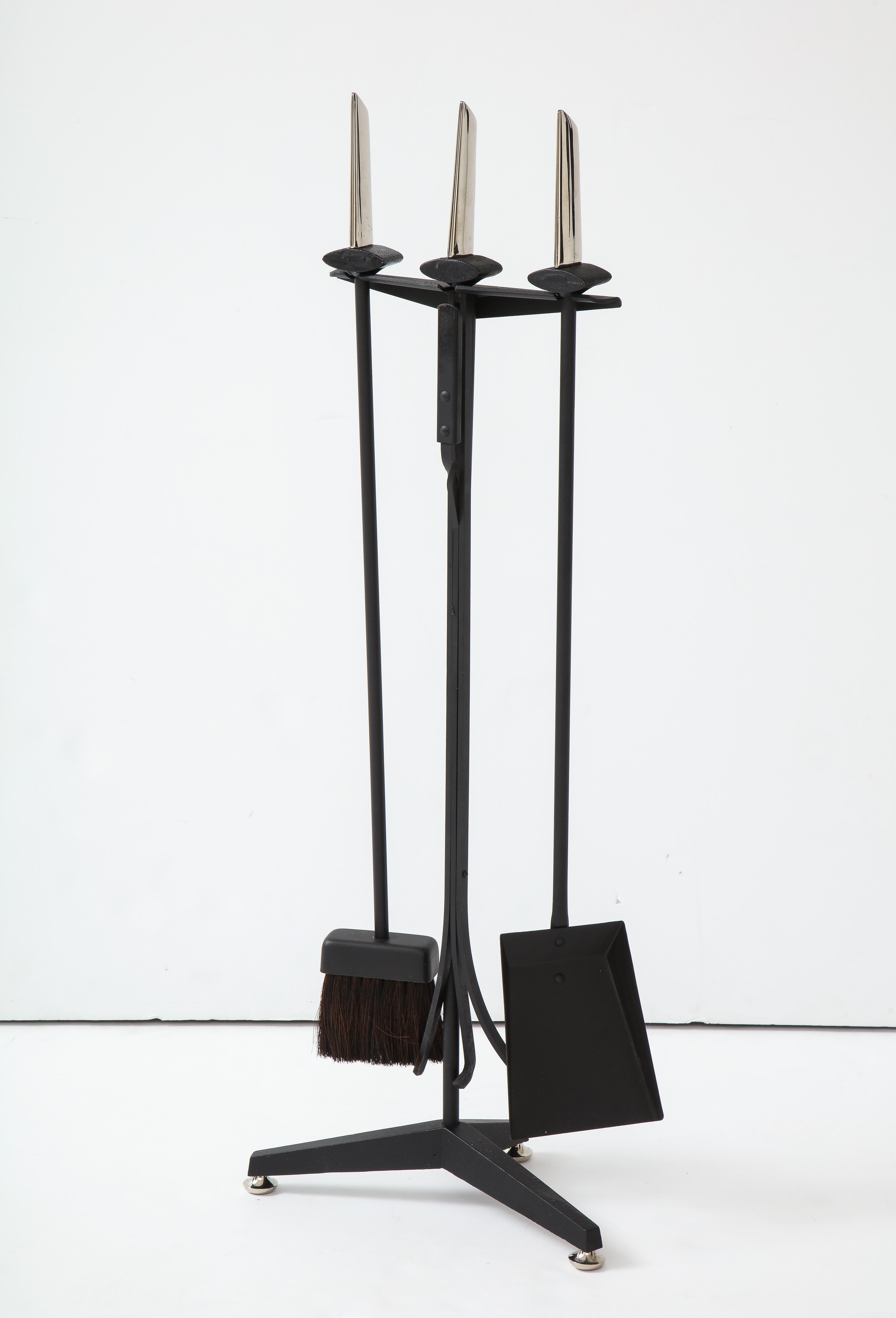 Modernist set of Art Deco fire tools in blackened iron with polished nickel blade handles and feet. Set includes stand, broom, tongs/poker, and shovel.