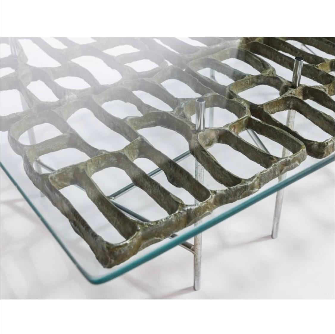 Interesting Brutalist coffee table by noted American sculptor and designer Donald Drumm. Coffee table with a tubular metal frame that supports a cast aluminum design and a rectangular glass top.Truly a piece of art , sculpture.  Hand delivery avail