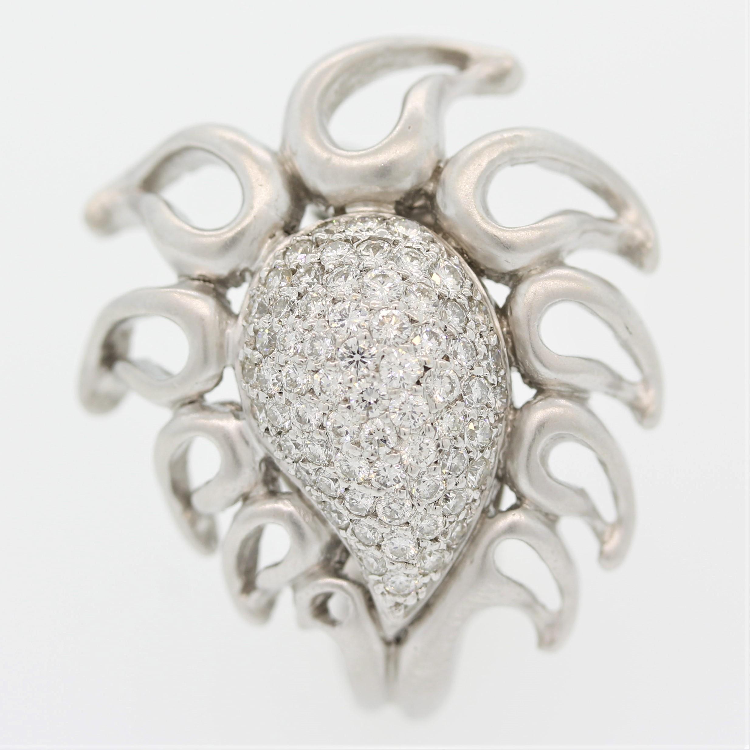 A lovey diamond ring by designer Donald Huber. It features 1.15 carats of fine round brilliant cut diamonds which are pave set with gold flames emanating around it. Made in 18k white gold, the piece has a soft satin finish that adds to the unique